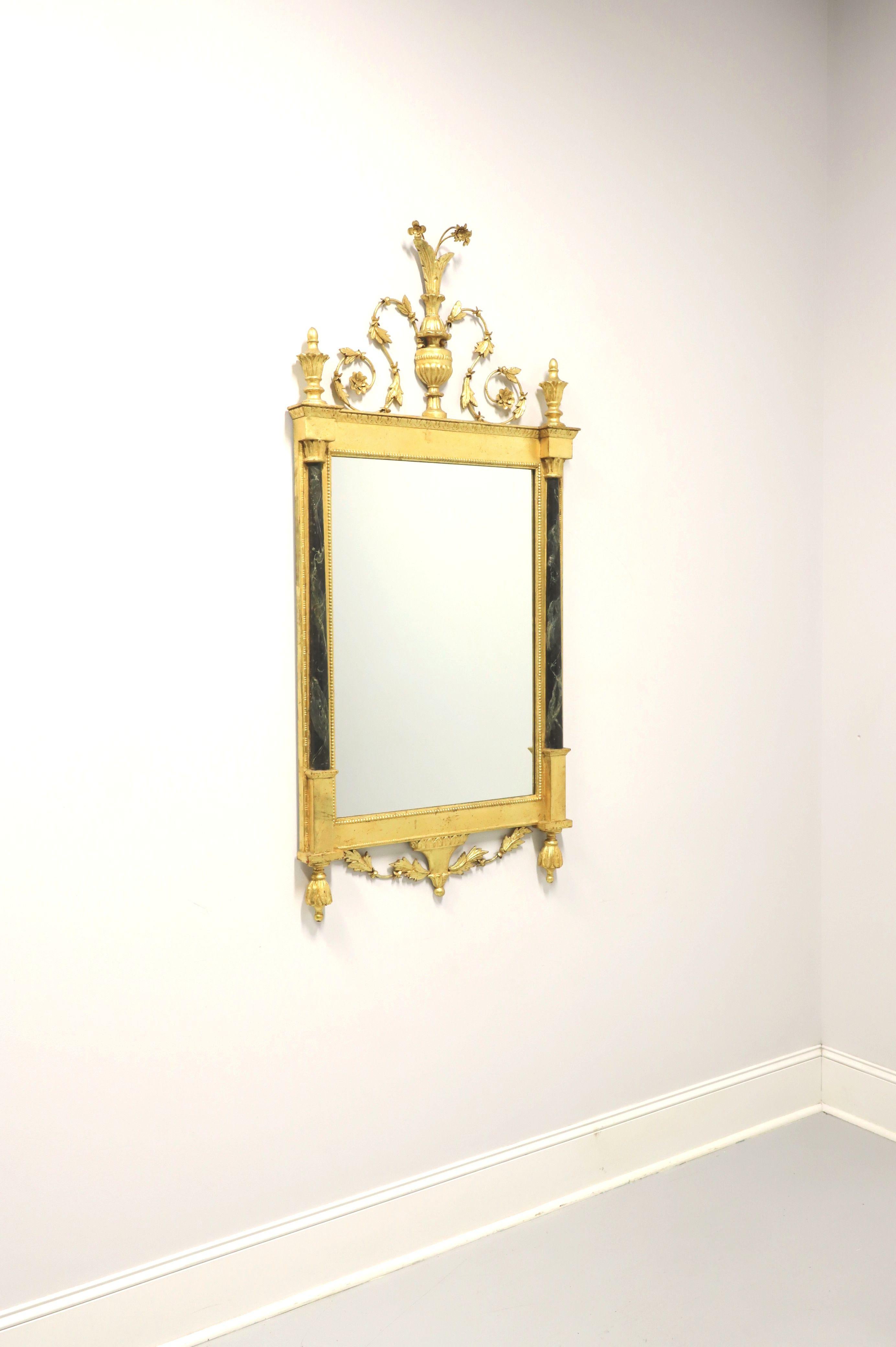 A Neoclassical style wall mirror, unbranded. Mirror glass in an ornate gold gilt wood frame with metal & wood foliate ornamentation and black marbleized side columns. Likely made in the USA, in the mid 20th century.

Measures: 28.75 W 3 D 59.5 H,