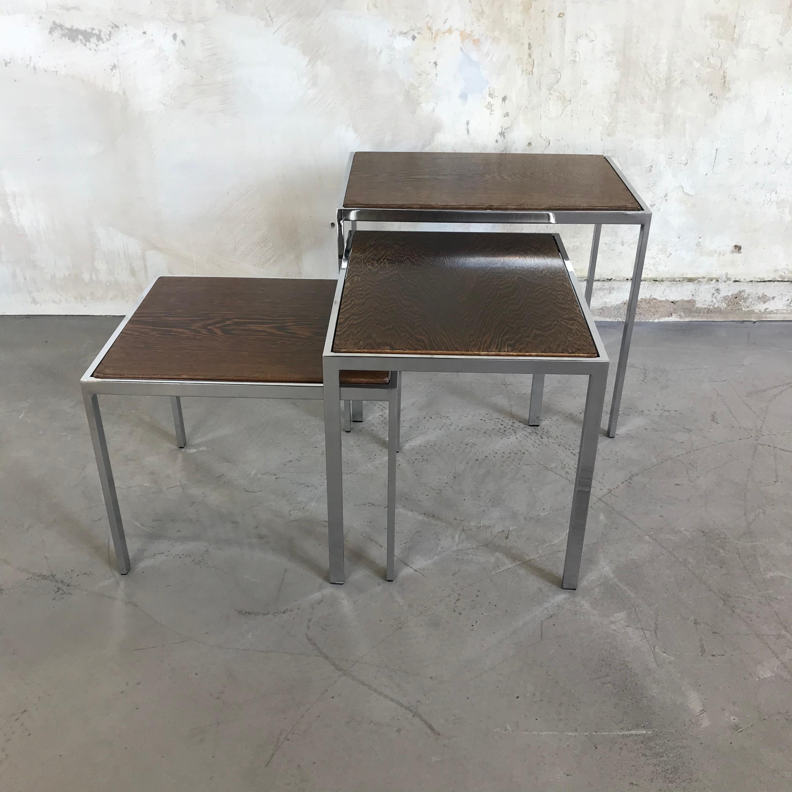 Beautiful set of 3 rosewood and chrome nesting tables. The tops are two-sided with white Formica on one side and rosewood veneer on the other. Chrome plated base. Good vintage condition with little signs of age and use.

Measures: Large 50 x 35