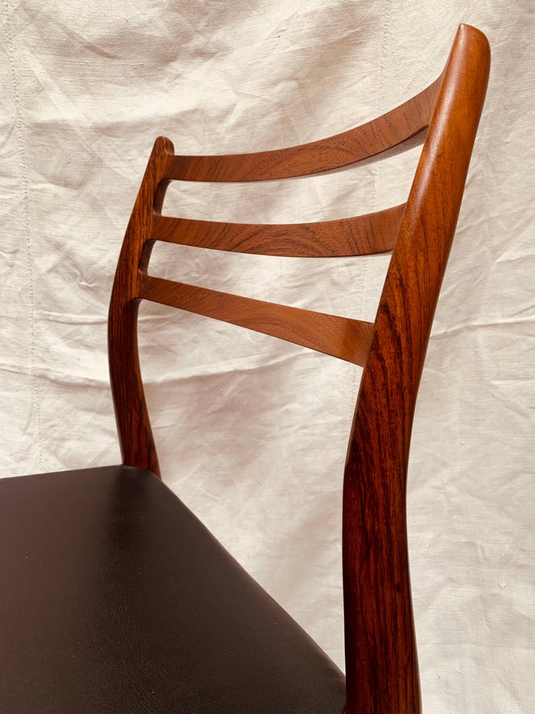A single 1960s Danish solid rosewood dining chair designed by Niels Otto Møller and manufactured by J. L. Møller Mobelfabrik, Denmark in 1962. The dining chair retains its original leather seat with no tears and very little wear. The chair is a
