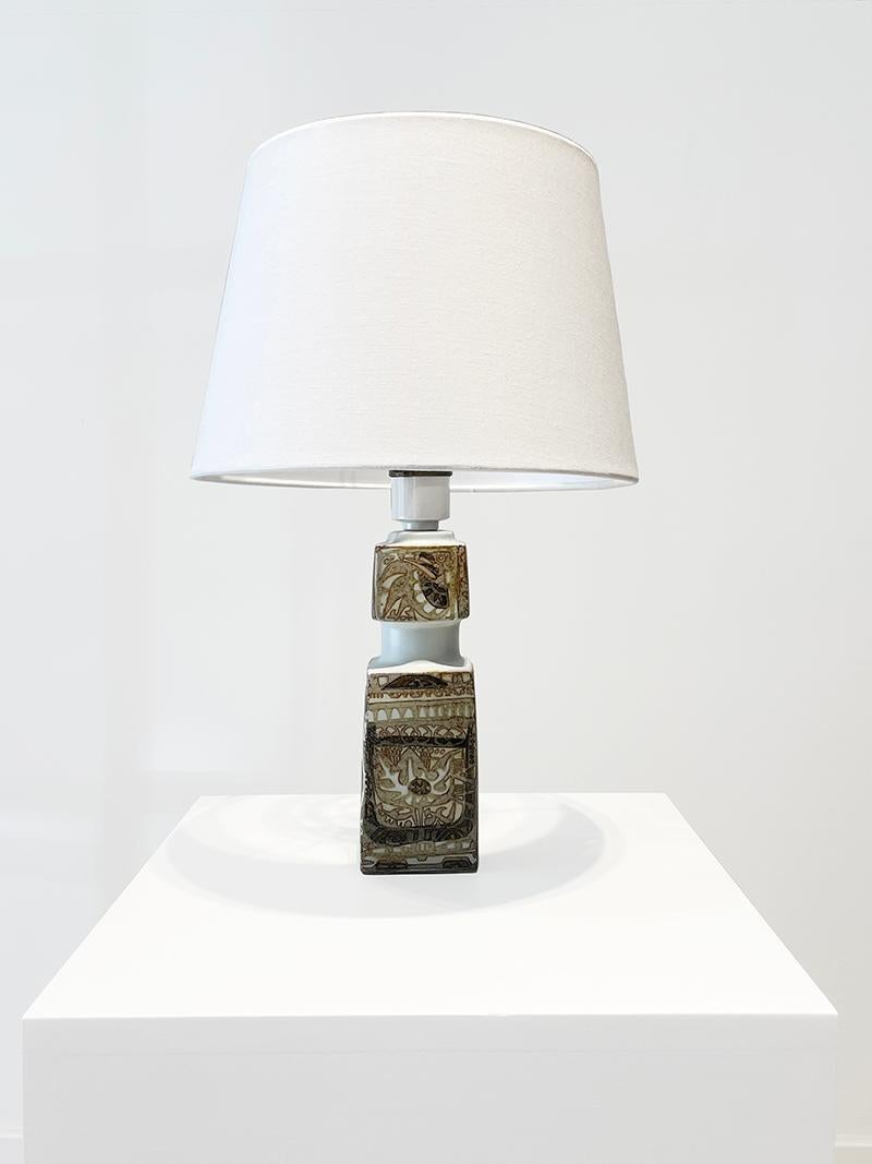 Table lamp designed by Nils Thorsson for Royal Copenhagen. 1960s.

This lamp consists of a square base foot decorated with the most recognizable motifs of the ceramist and designer; Mythological animals, flowers, geometric motifs