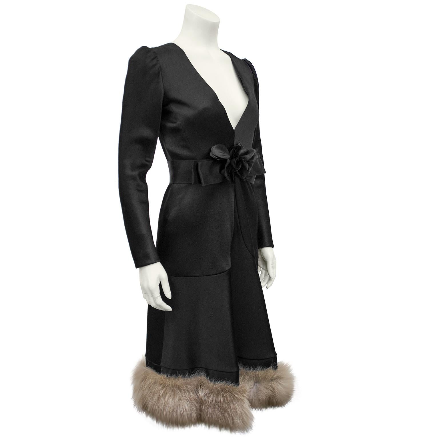 Nina Ricci black satin long sleeve cocktail dress from the 1960s that is to die for. The back has large black satin covered buttons that travel up the back and the front deep V neckline is accented with a wide black satin belt, worn at the natural