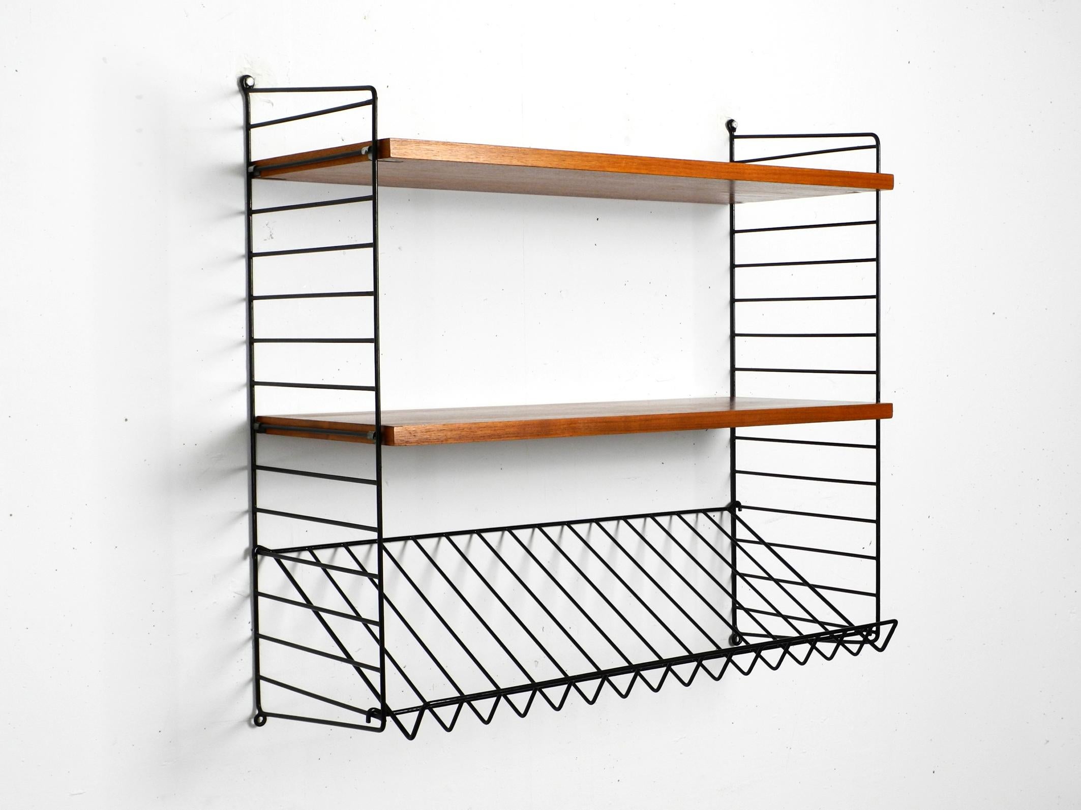 Original 1960s Nisse Strinning String teak wall shelf. Made in Denmark.
Two ladders with two shelves with a depth of 30 cm and one magazine rack.
All wooden parts are covered with teak veneer.
Very clean with few normal signs of use.
All ladders are