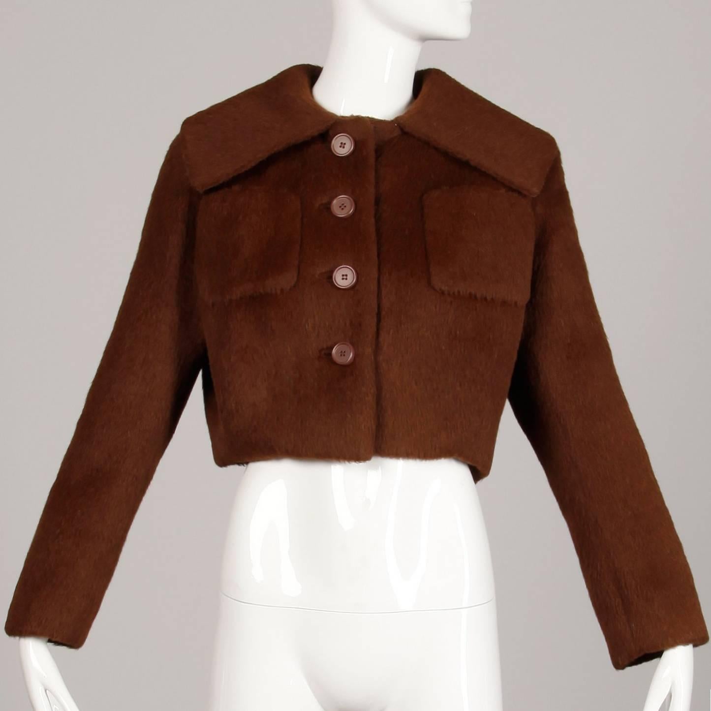 Absolutely stunning construction! Vintage 1960s Norman Norell brown wool jacket with a pop up portrait collar. Fully lined in silk with front button and snap closure. Front patch pockets. Fits like a size medium-large. The bust measures 44