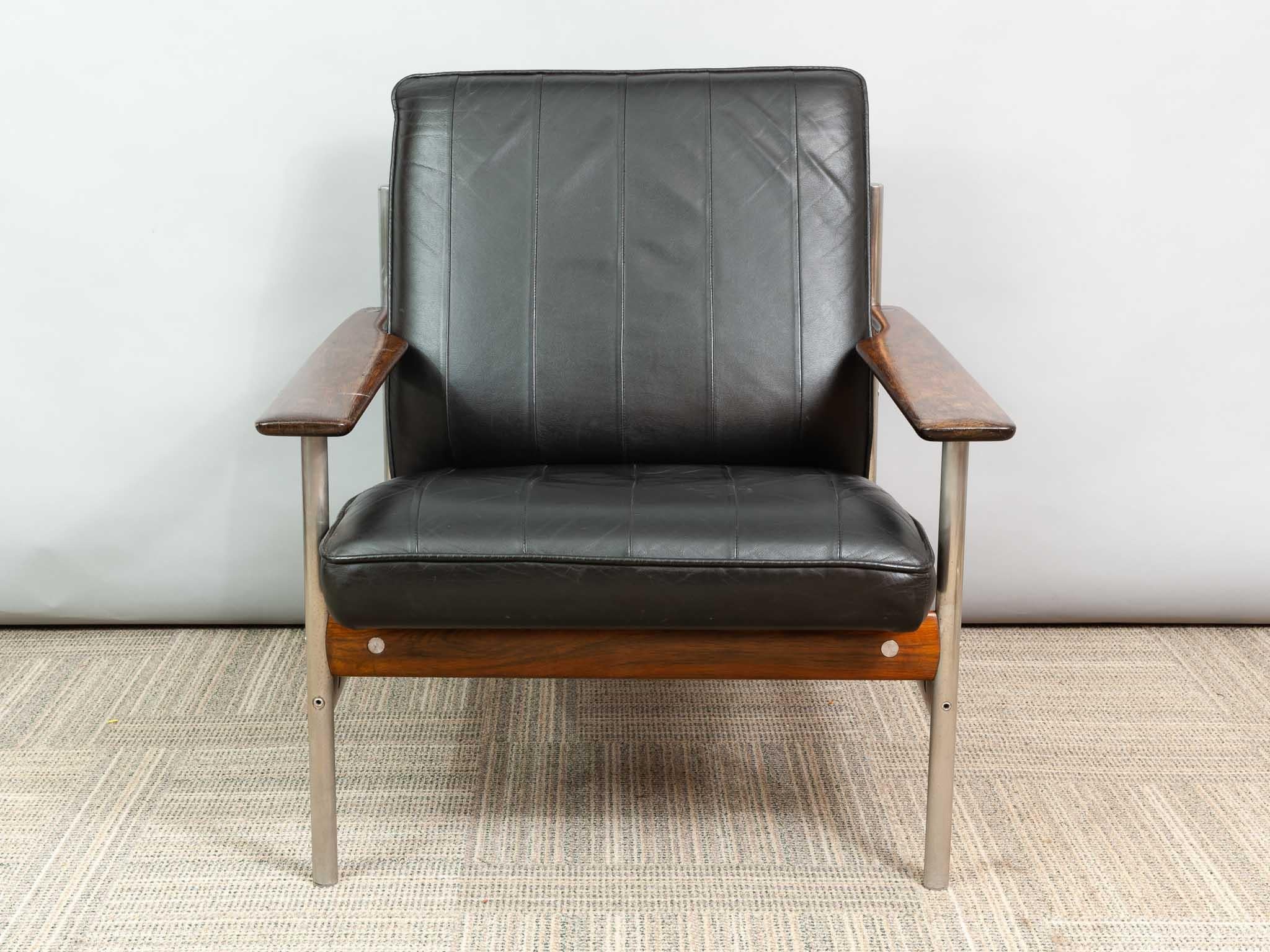 An original 1001 AF low lounge armchair designed by Sven Ivar Dysthe and manufactured in 1959 by Dokka Mobler in Norway. The frame is manufactured from a combination of Rosewood, chrome-plated metal tubes and black leather upholstery.

The black