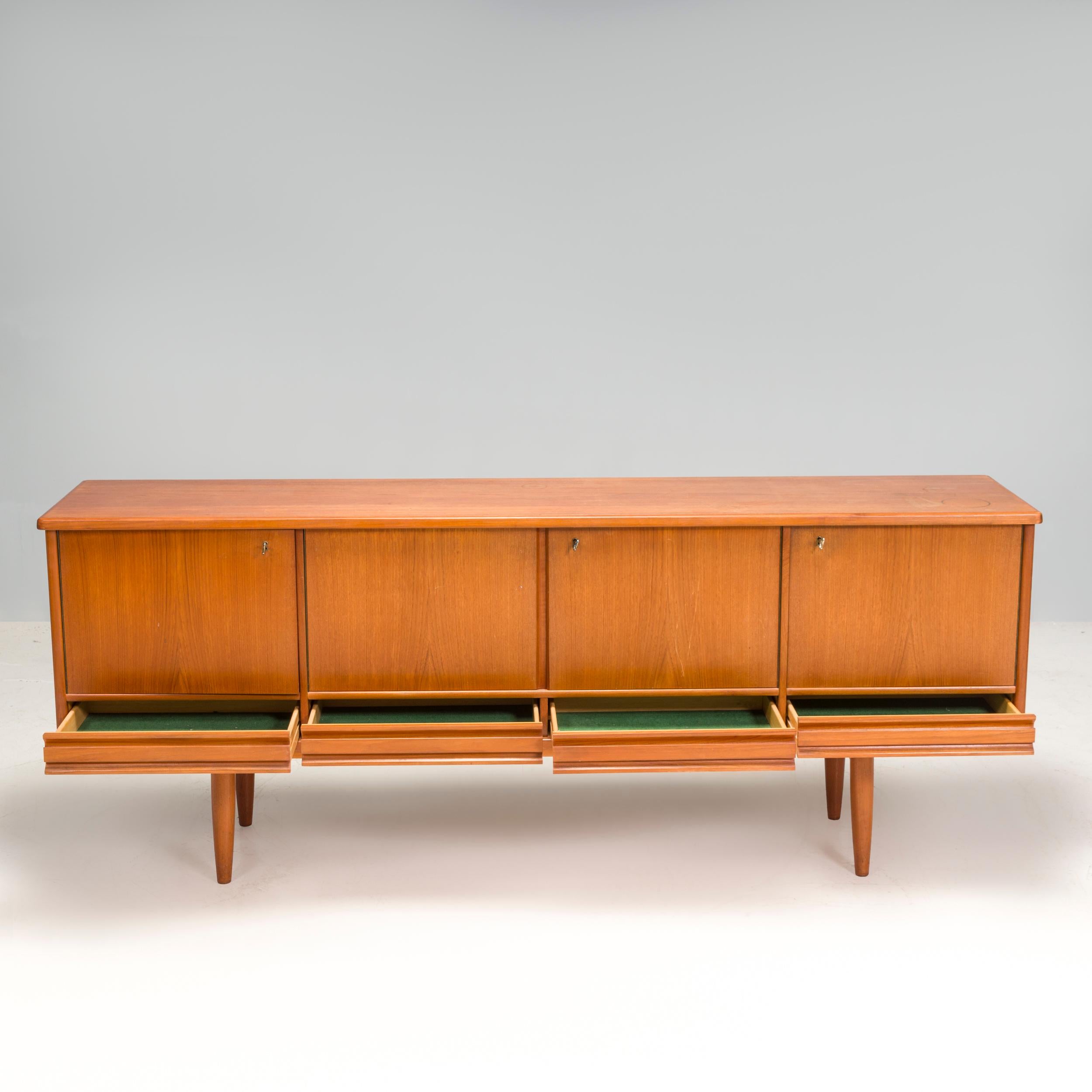 This teak sideboard comes from Norway produced by  Nordås Bruk A/S and was made around 1960s. 

We like the sleek lines of this well made teak sideboard with all the drawers hidden inside the cupboard doors . It features three storage sections,