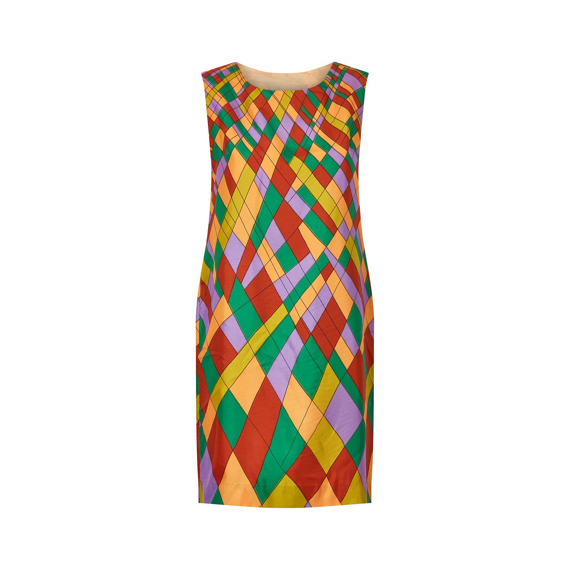 This 1960s shift dress is made from a silky satin feel fabric and is very tactile. It has a high, rounded neckline and loose, flowing shape from bust to hem. The print is reminiscent of the mod trends for bright, bold colours and patterns which