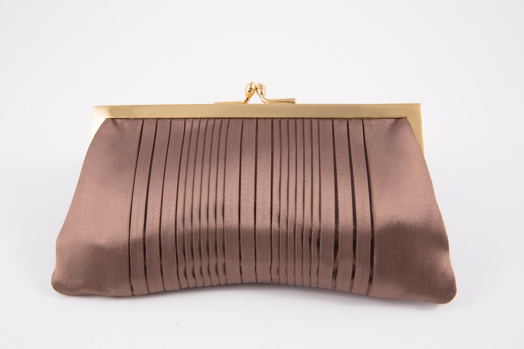 1960s Nut silk clutch featuring a center front pleat detail, a top gold tone claps opening, an inside ivory silk lining, an inside slip pocket.  
Length 8.4in. (21 cm)
Height 4.3in. (11cm)
Depth 0.8in. (2cm)
In good vintage condition. Made in