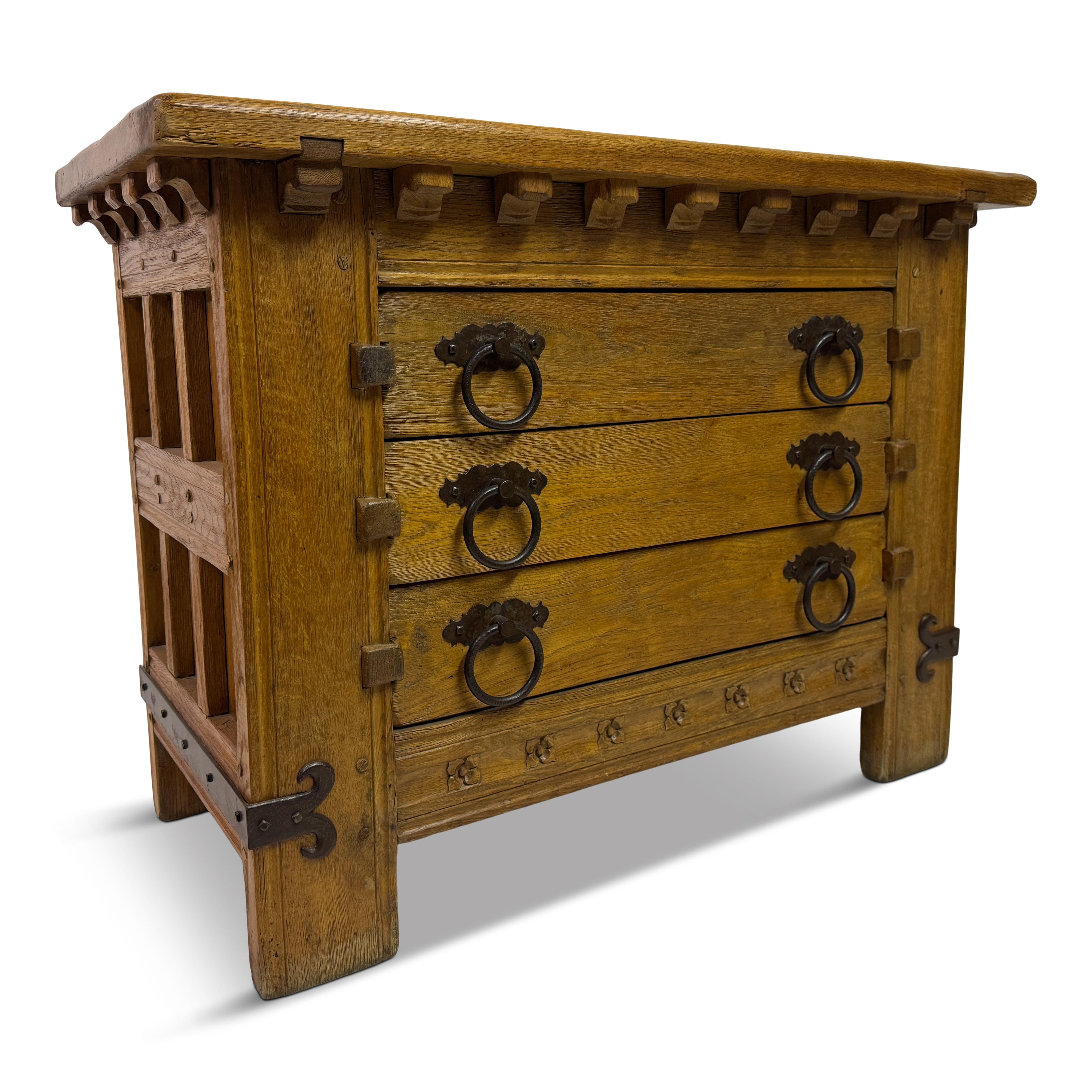 1960s Oak Chest of Drawers with Decorative Ironwork

A distinctive 1960s chest of drawers in solid oak, notable for its bold silhouette and richly detailed iron accents. This piece draws inspiration from medieval and rustic architectural forms, with