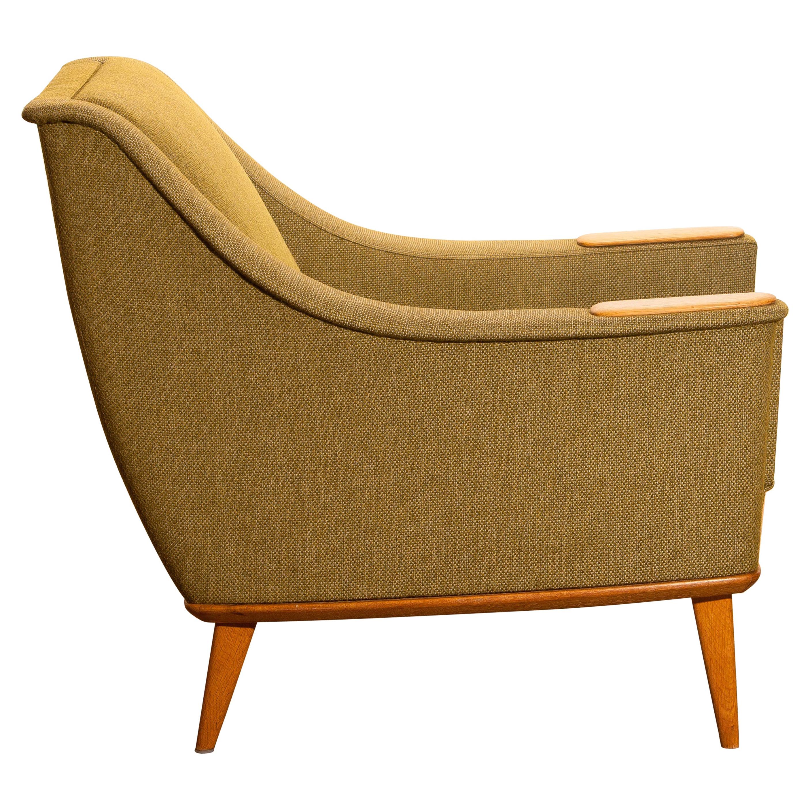 Beautiful and original midcentury lounge or easy chair with oak details by Folke Ohlsson for DUX, Sweden.
This chair sits extremely comfortable and is in good condition.

Period: 1960.
The dimensions are: Depth 77 cm, 30 inch, wide 77 cm, 30