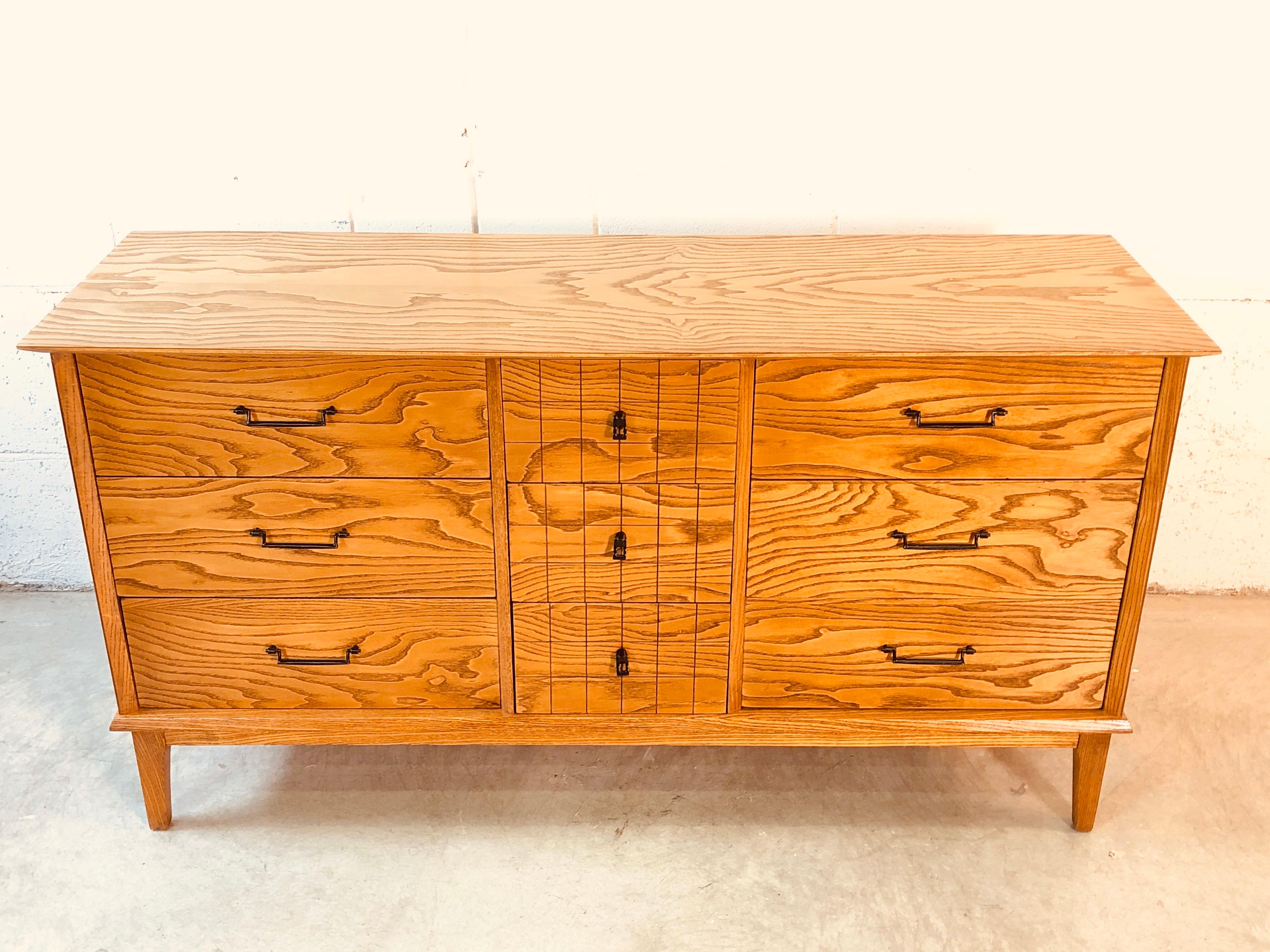 1960s solid oakwood dresser with a dark wood grain. The dresser has nine drawers for storage. It is fully refinished and the grain is beautiful! There are no marks. Excellent condition.