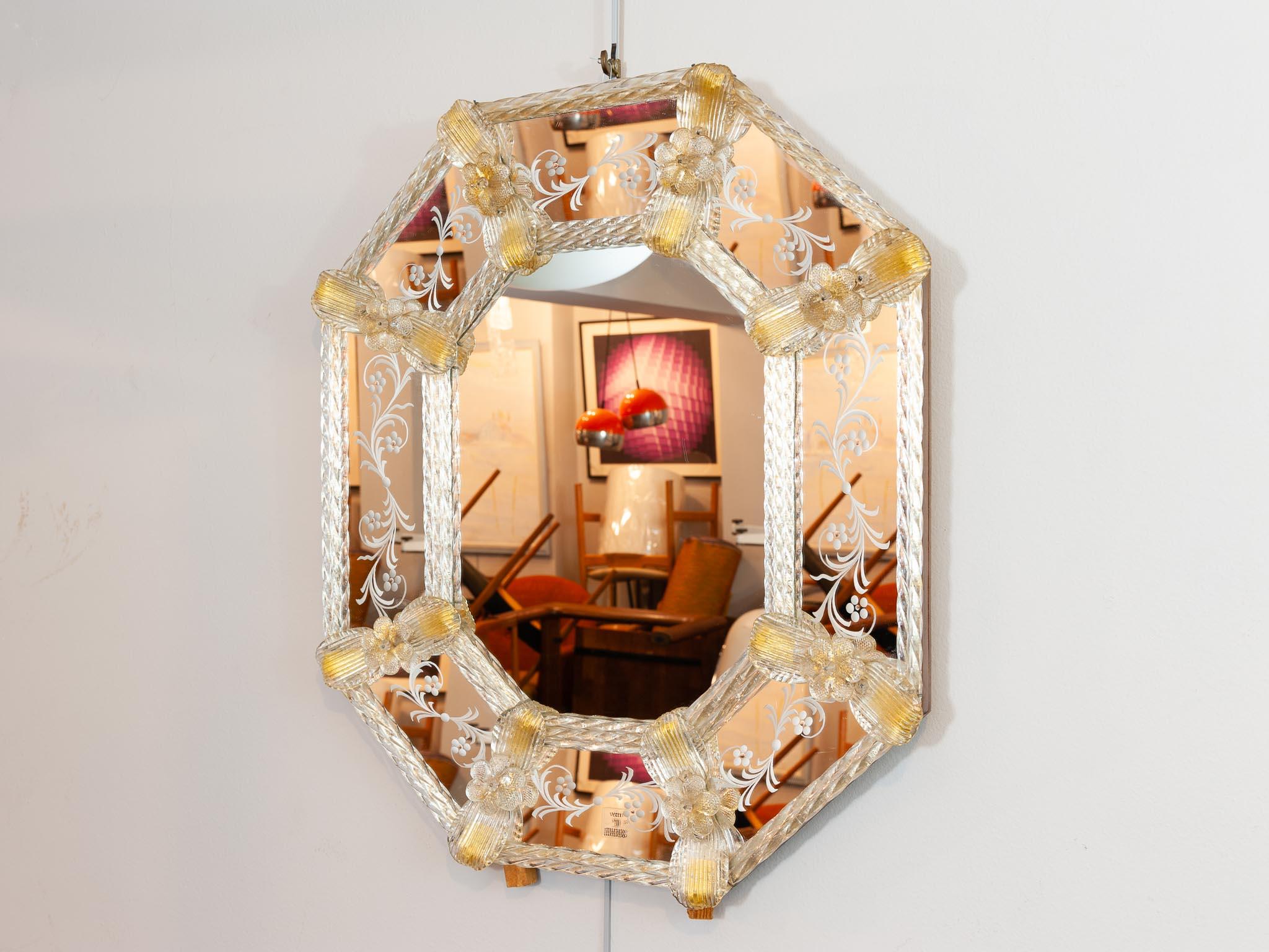 A beautiful 1960s octagonal Italian wall mirror with etching on the surround and floral detailing which hold the glass rods in place at either end of the leaves. The flowers and leaves contain gold-flecks which contrast against the rest of the