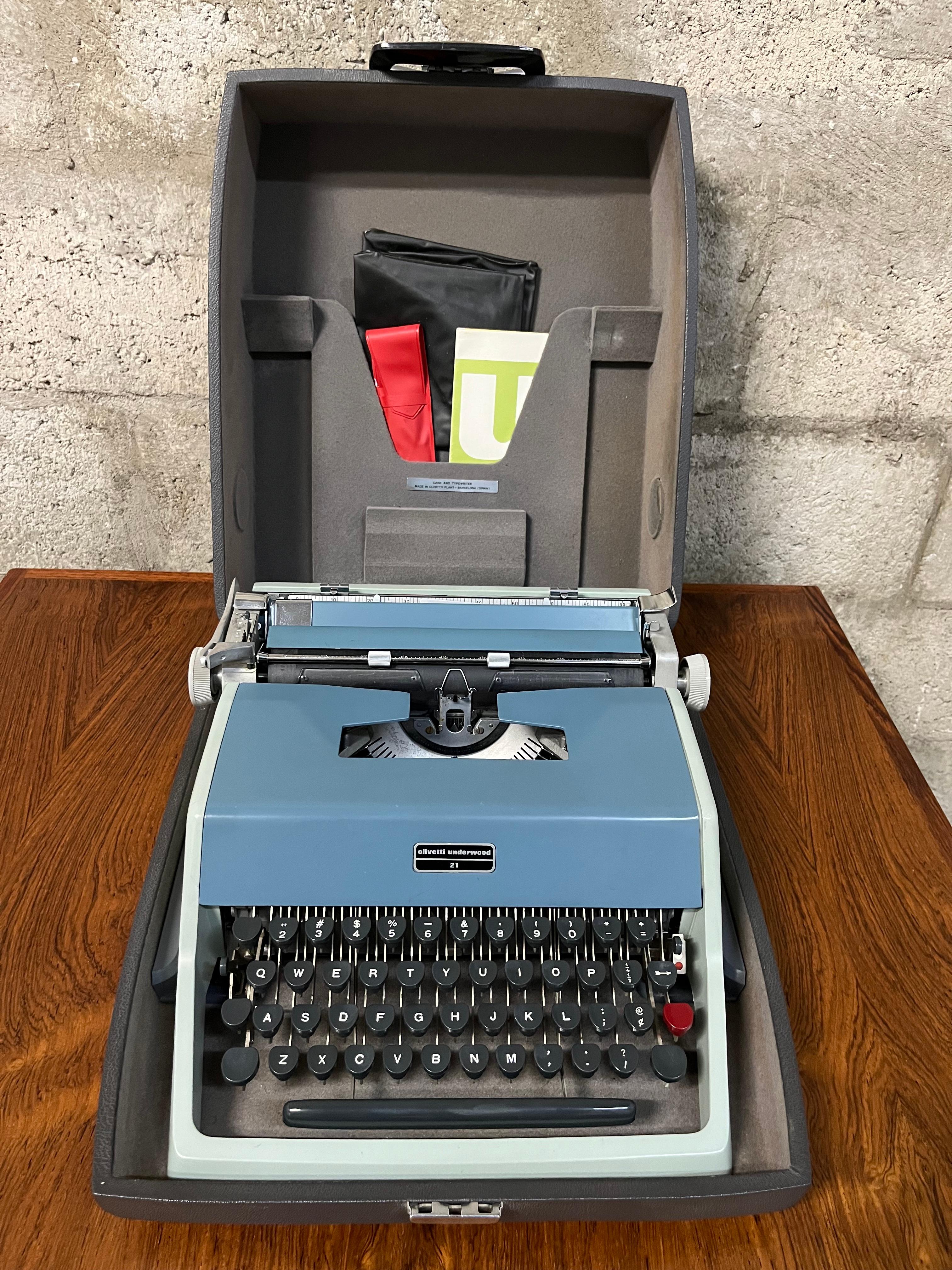 Vintage Mid Century Modern Olivetti Underwood 21 Portable Typewriter With Original Case Circa 1960s 
Features a QUERTY keyboard, a teal and light blue metal body with a dark gray plastic portable case.
It comes with the original instruction manual
