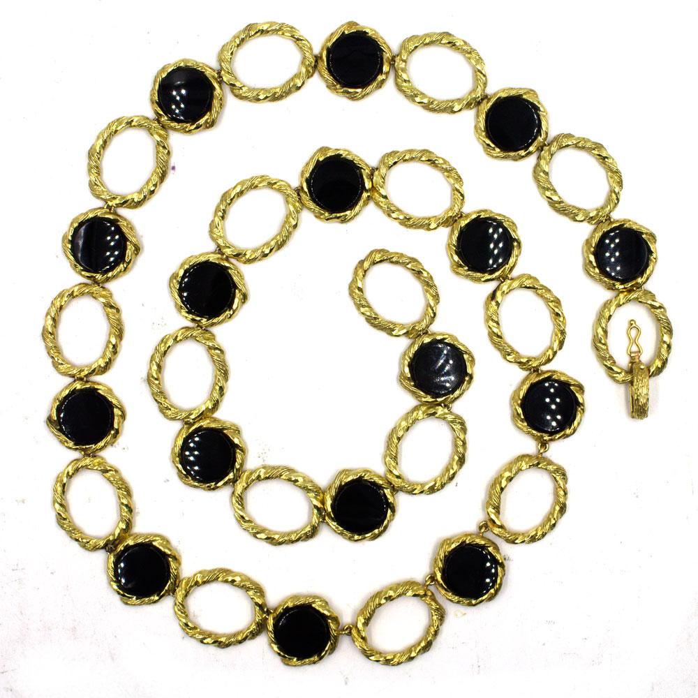 This stand out necklace circa 1960's is hand crafted in 18 karat yellow gold. The alternating links feature round onyx with gold outline and oval open textured gold links. The necklace measures 30 inches in length and .80 inches in width. Signed R.