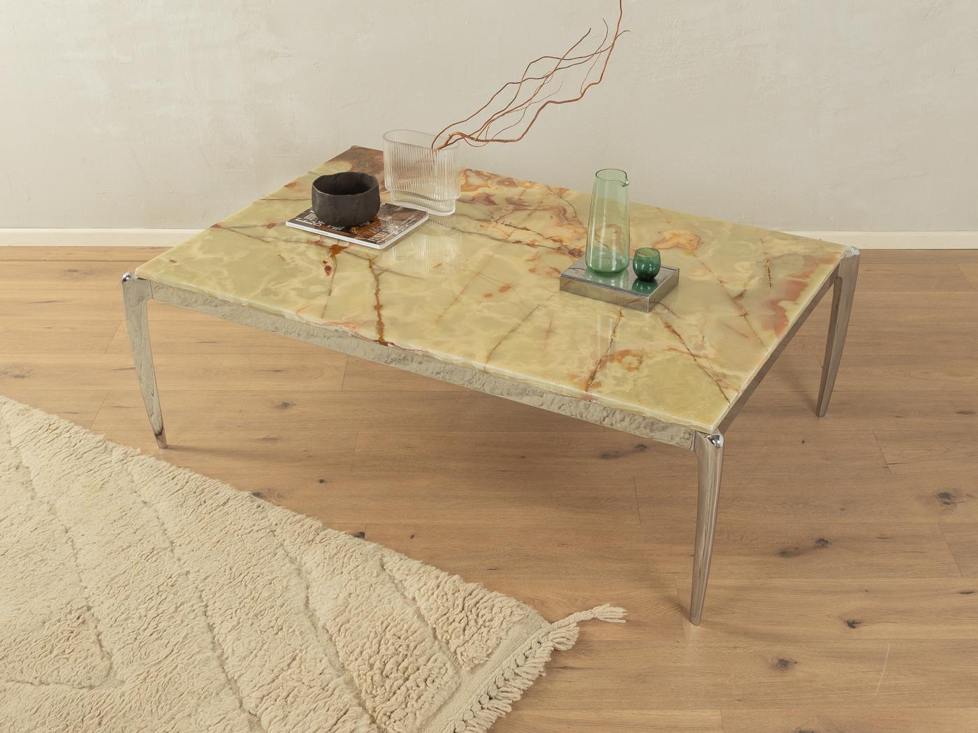 Wunderschöner Couchtisch aus den 1960er Jahren. Gestell aus verchromtem Edelstahl mit einer Tischplatte aus Onyxmarmor in Creme- und Brauntönen.

Qualitätsmerkmale:

    sehr gute Verarbeitung
    Hochwertige MATERIALIEN
    Hergestellt in