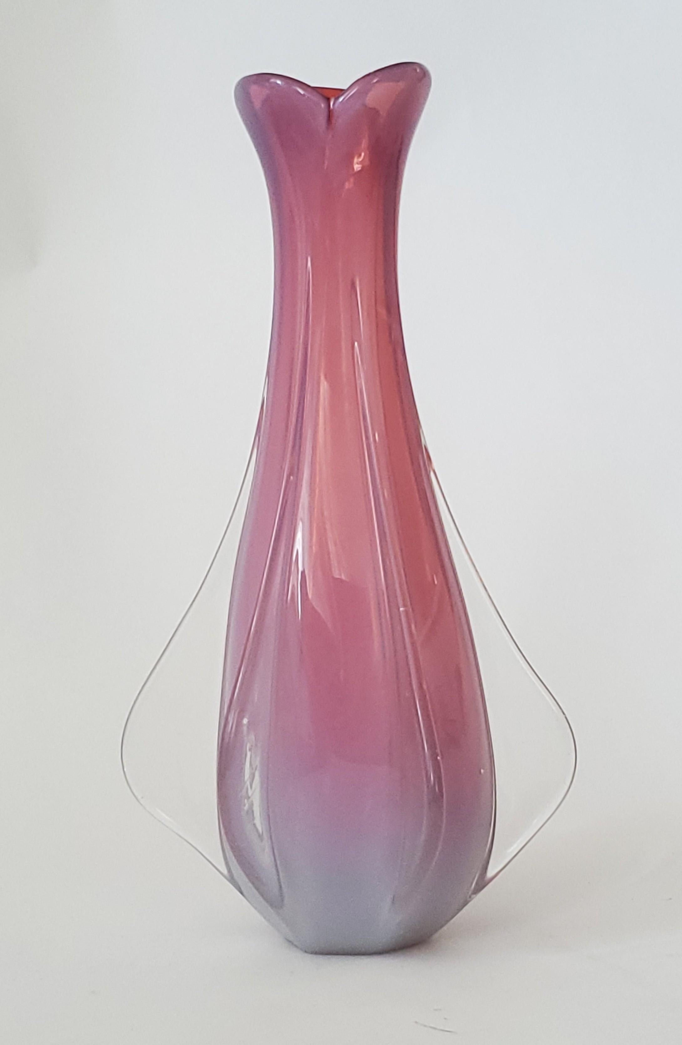 Offriamo un vaso in vetro di Murano soffiato a mano vintage degli anni '60, firmato con etichetta sul fondo. Questo splendido vaso è di colore bianco opalescente all'esterno e rosa brillante all'interno e conferisce a questo vaso alto un aspetto