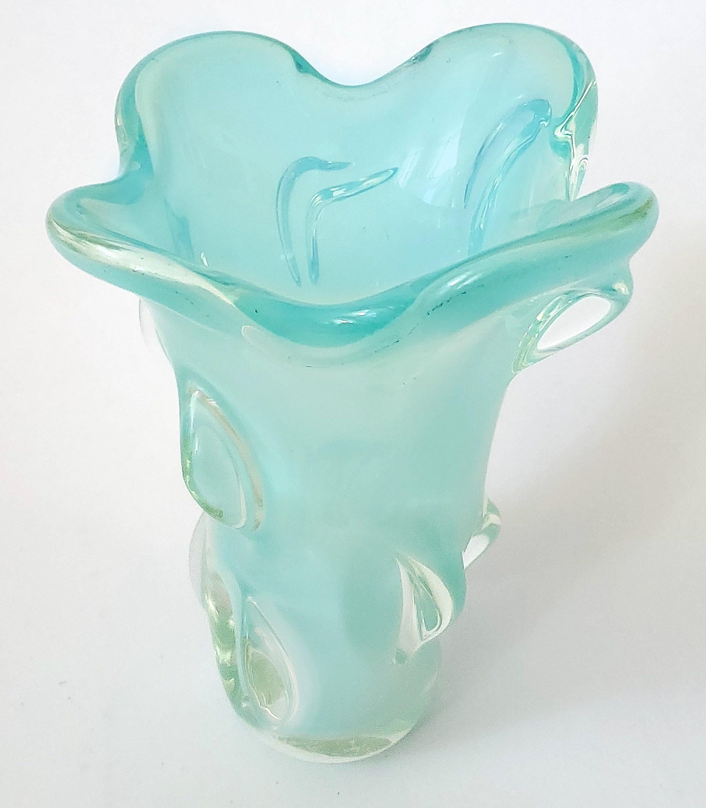Offriamo un vaso in vetro di Murano soffiato a mano vintage degli anni '60, firmato con etichetta sul fondo. Questo splendido vaso ha un colore bianco opalescente all'esterno e un turchese chiaro all'interno che conferisce a questo vaso pesante un