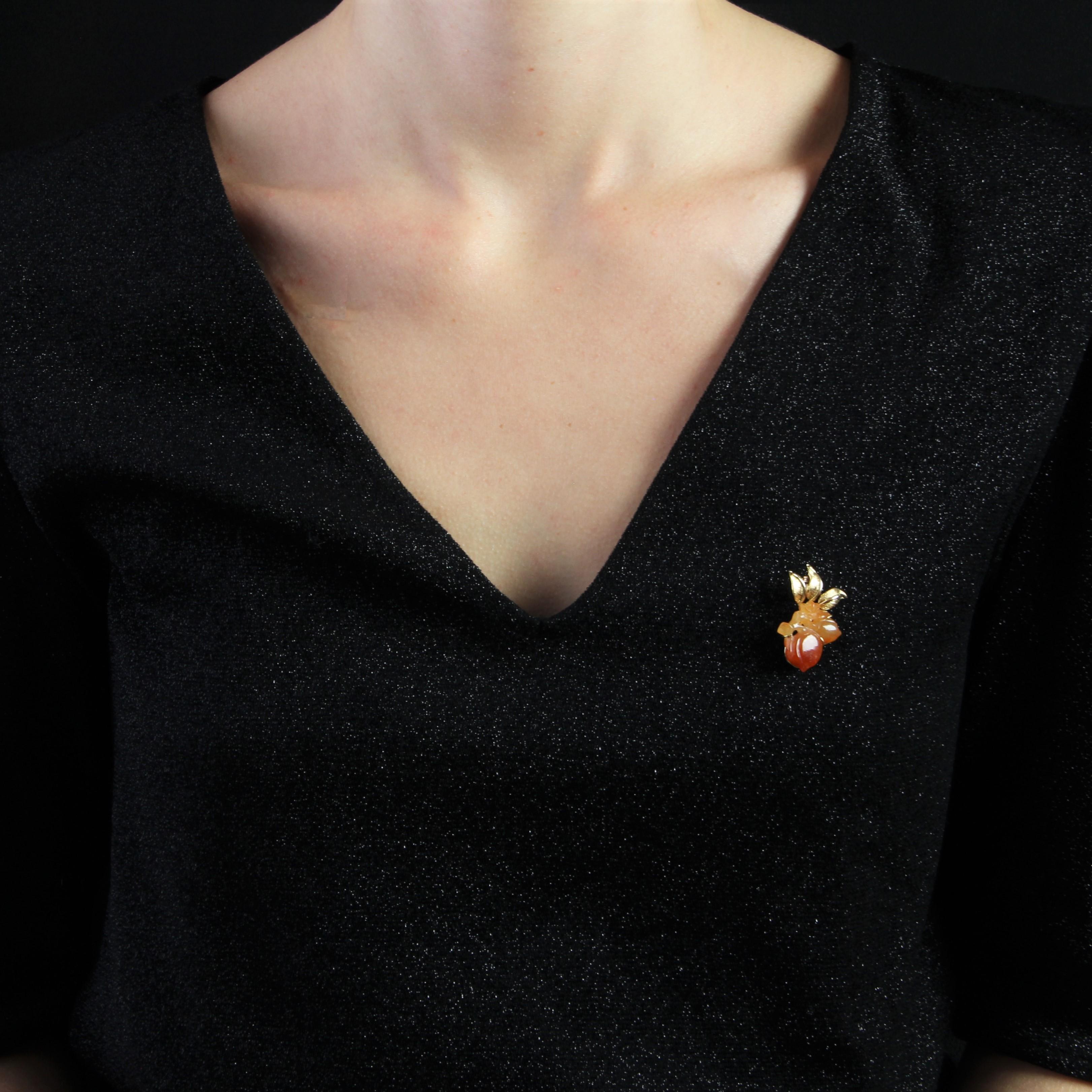 Brooch in 18 karat yellow gold, own hallmark.
Original retro brooch, it formed a chased gold foliage and its fruit made of engraved orange to brown jade. The attachment system is a pin with a safety hook.
Height : 2.4 cm, width : 3.4 cm, thickness :