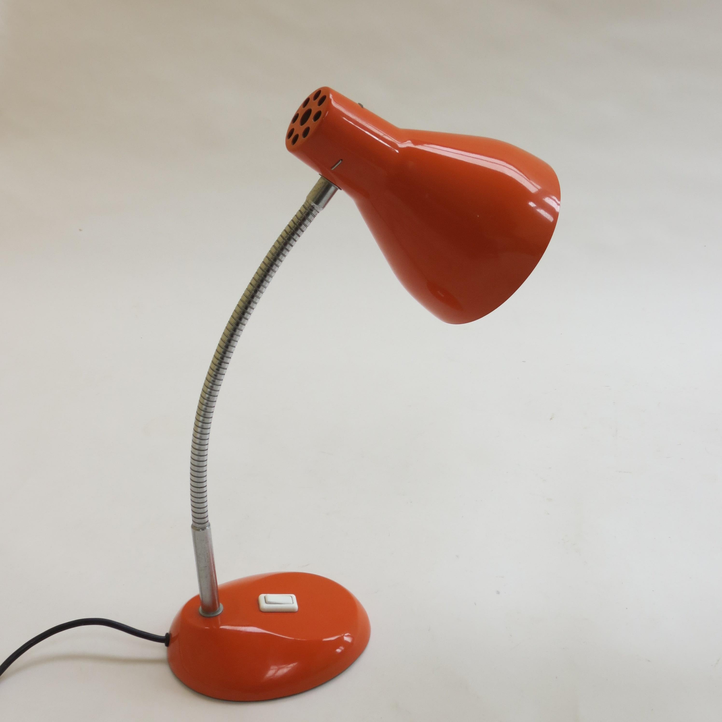 Vintage desk lamp by H Terry and Son. Dates from the 1960s. Orange metal shade and base with flexible neck allowing the lamp to be adjusted to suit. 

Green baize to the underside along with sticker that reads Made in England, H Terry and Son