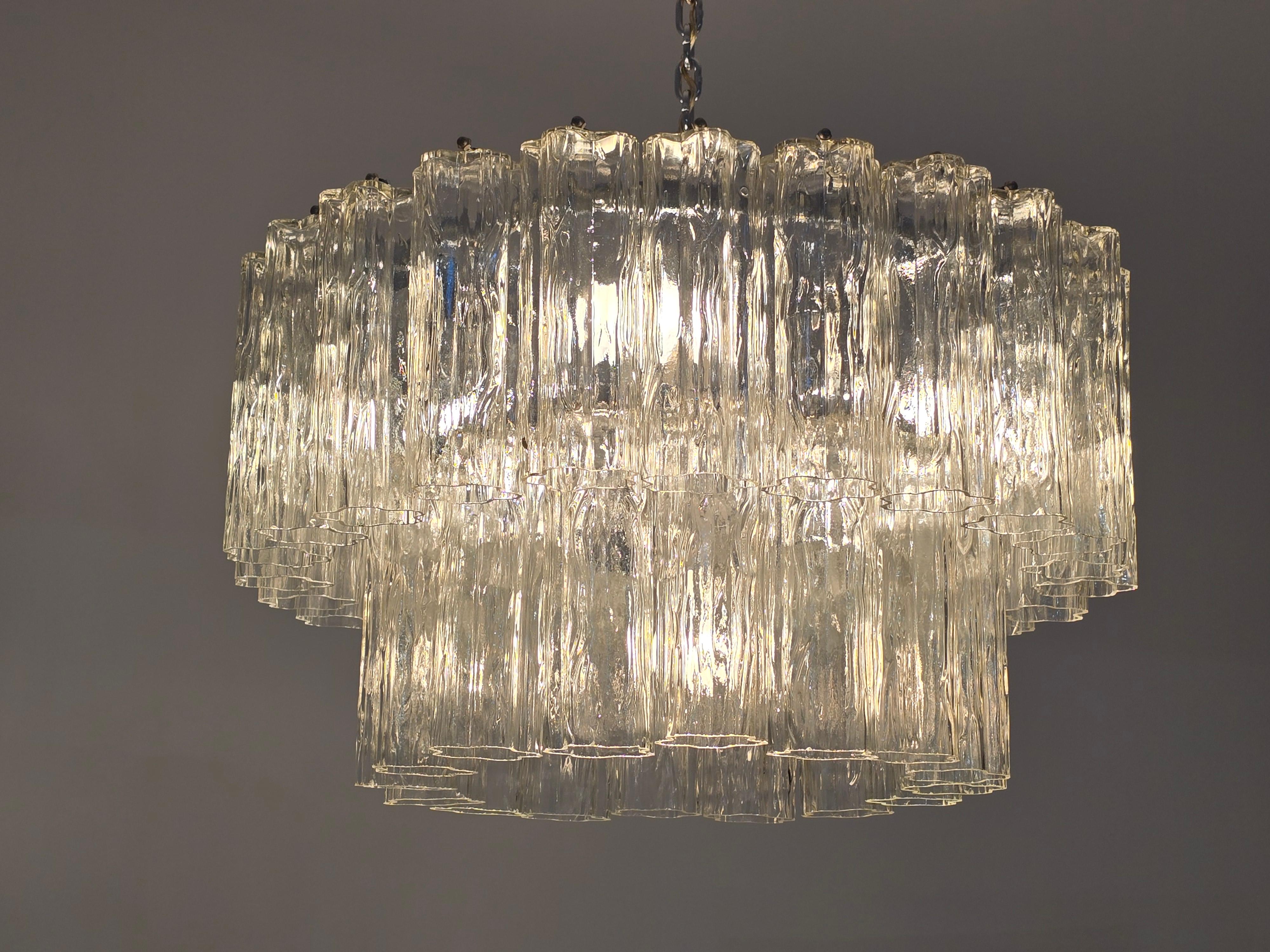 Lampadario a tubo in vetro trasparente 'Tronchi' originale degli anni '60  da Venini. 

Contenere 4  Presa in porcellana E26 / E27 . 

Telaio cromato fatto a mano.

La lunghezza effettiva della catena è di 26 cm più 15 cm per il lampadario.  per una