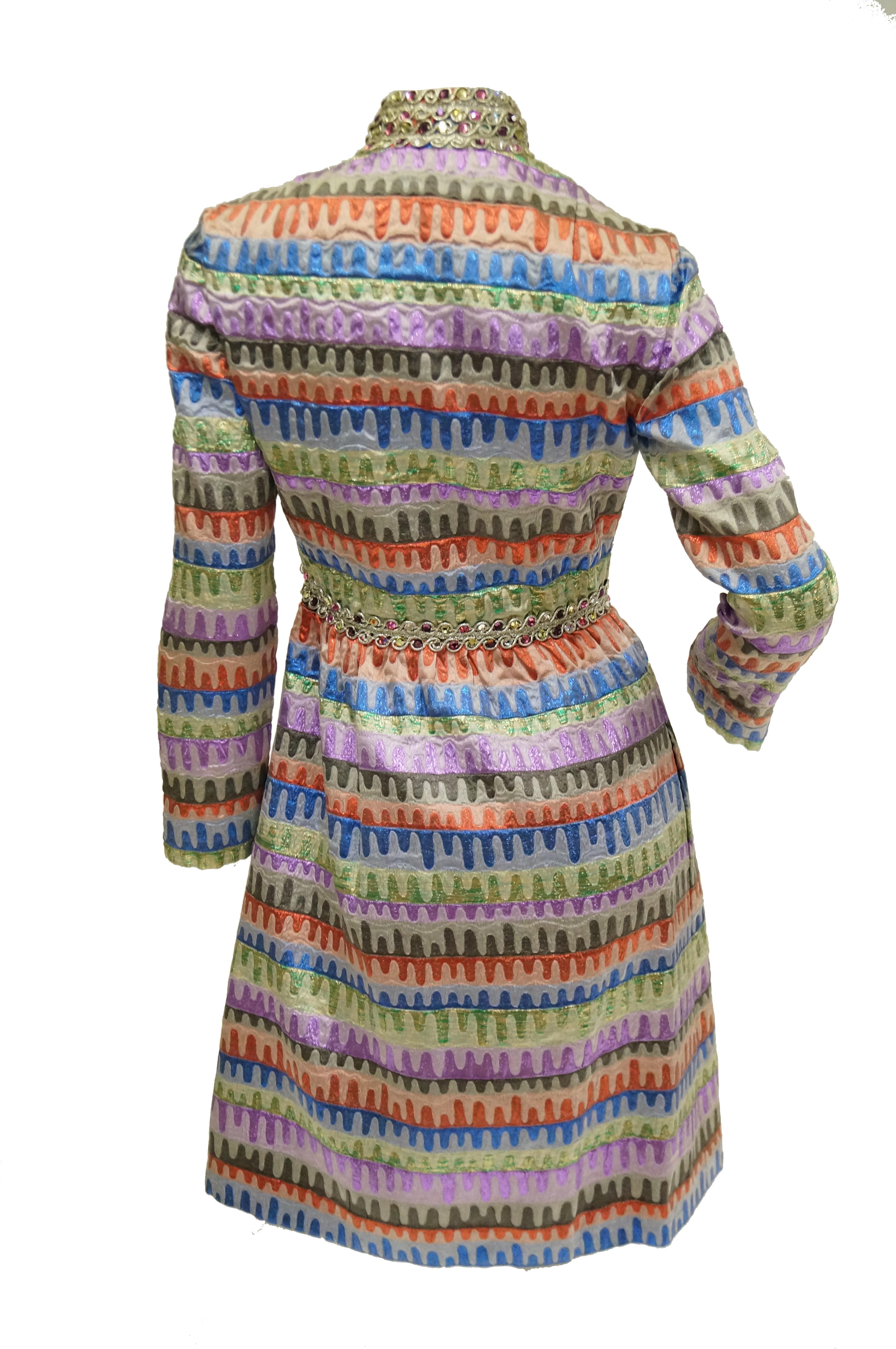 Simply stunning multicolor party dress by Oscar! This gloriously 60s piece features a knee - length hem, A - line silhouette, long sleeves, and mandarin collar. The dress is composed of an amazing brocade fabric with red, blue, green, purple, and