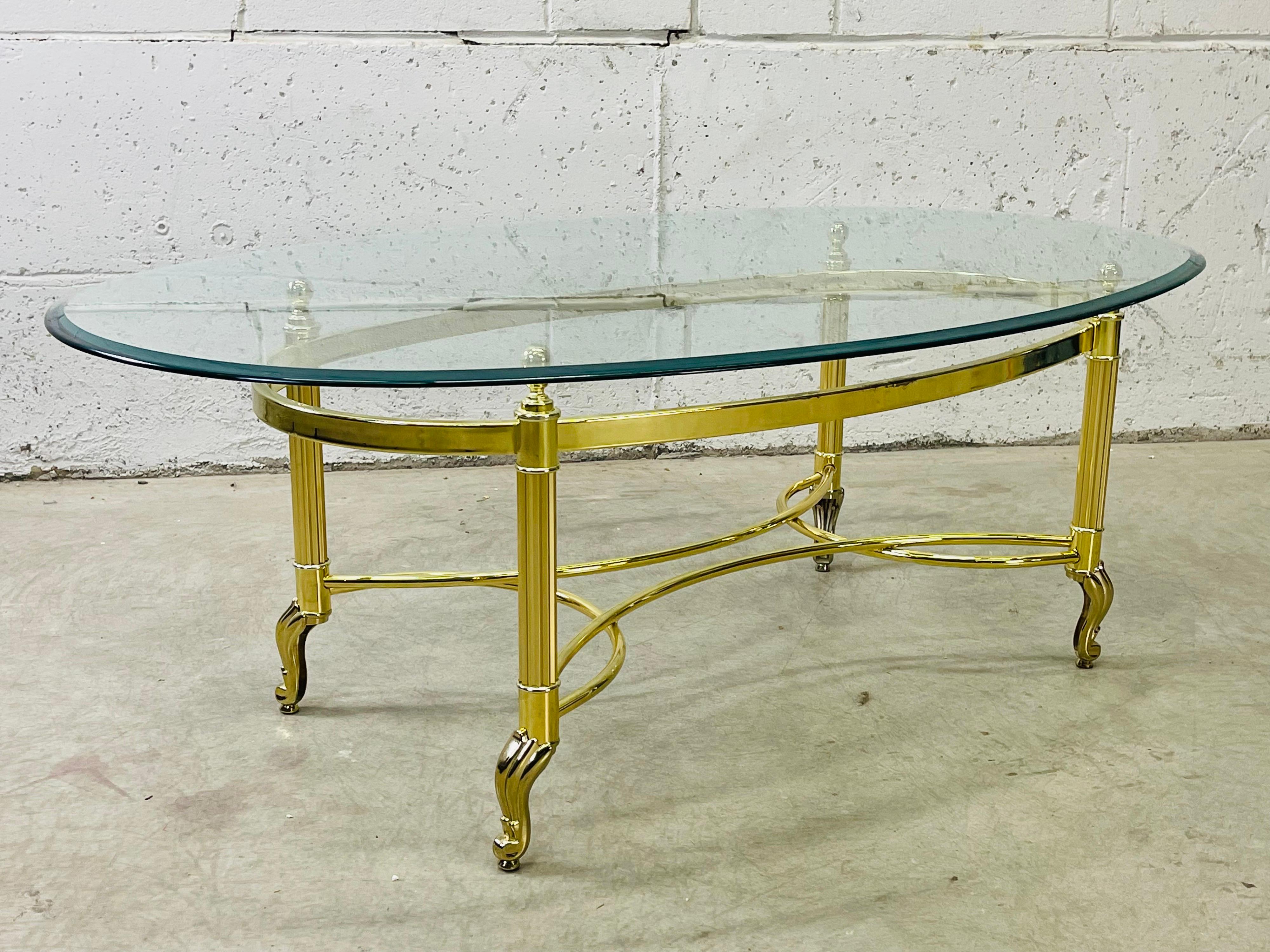 Vintage 1960s Le Barge style oval glass top and gilt metal base coffee table. The glass top is beveled along the edges. Very good used condition. No marks.
