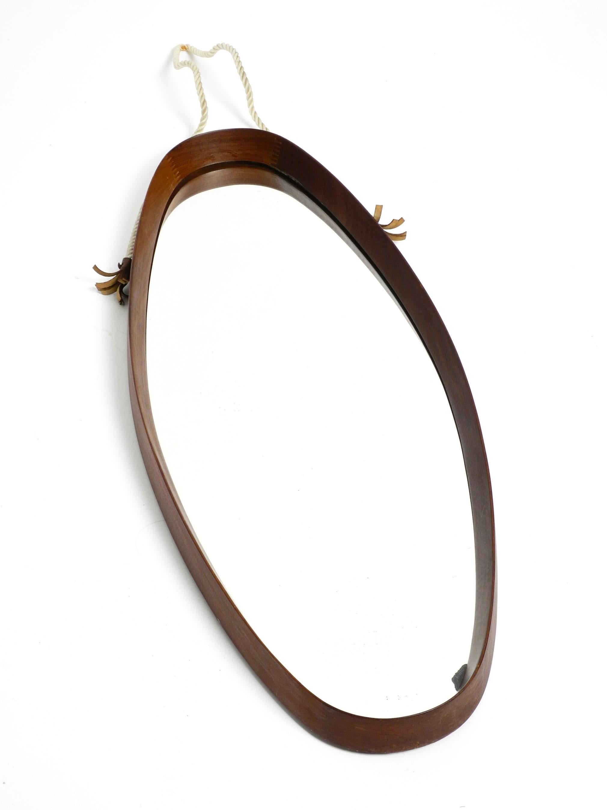 Original 1960's beautiful large oval wall mirror with a teak frame. Made in Italy.
Very high-quality workmanship in a minimalist Italian design.
The original thick nylon hanging rope is undamaged and firm.
By hanging it, the nylon rope gets straight