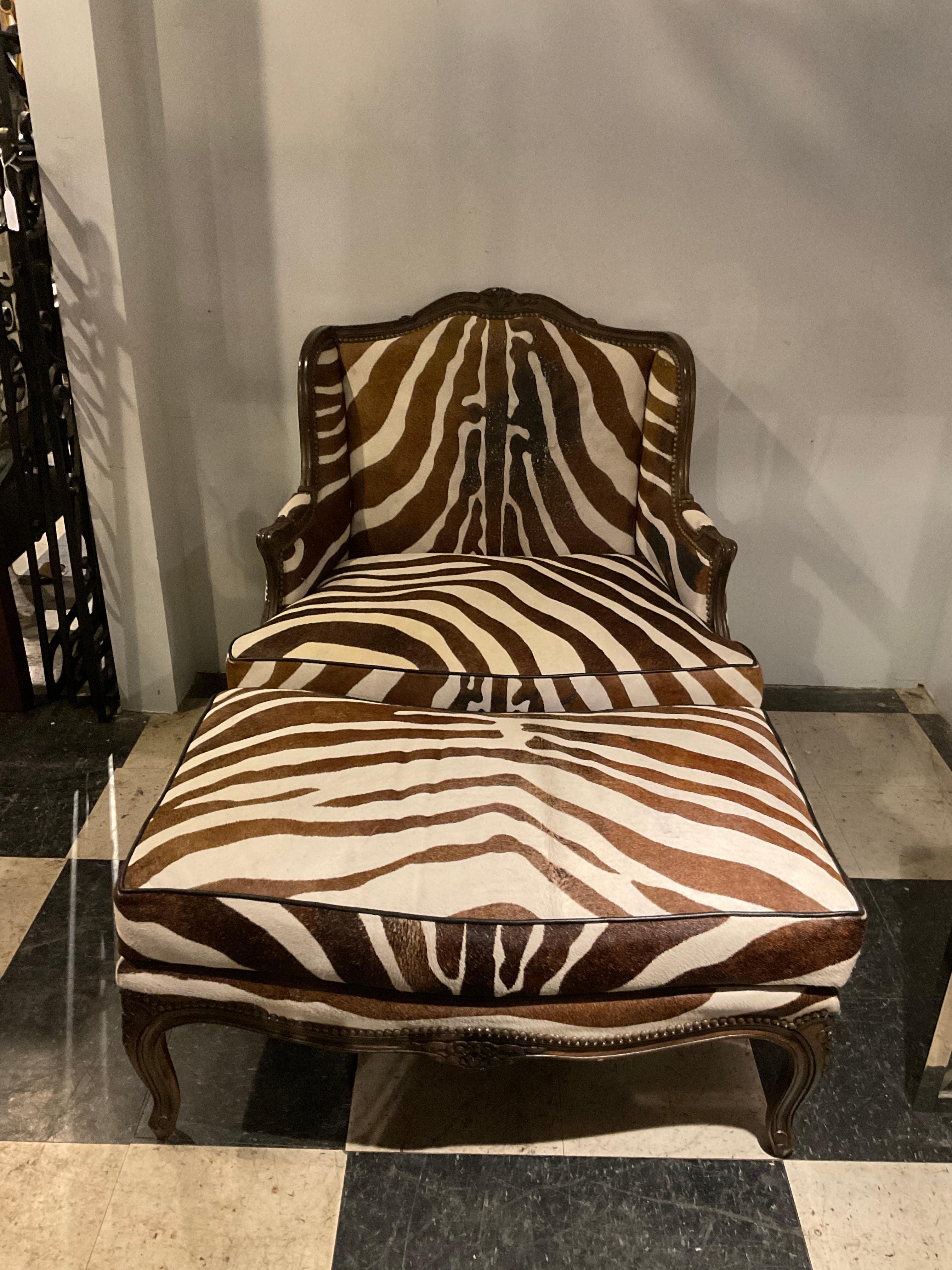 1960s carved wood oversized bergere and ottoman upholstered in zebra pattern cowhide. 