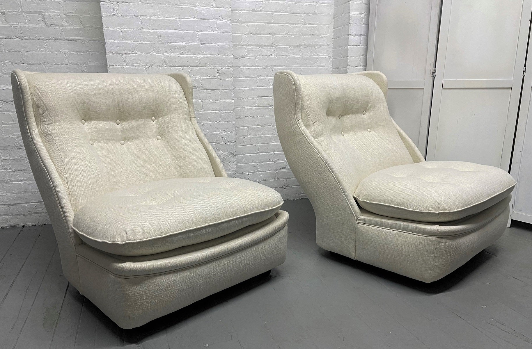 Pair of 1960s oversized slipper lounge chairs. The chairs are newly upholstered with black lacquered legs.