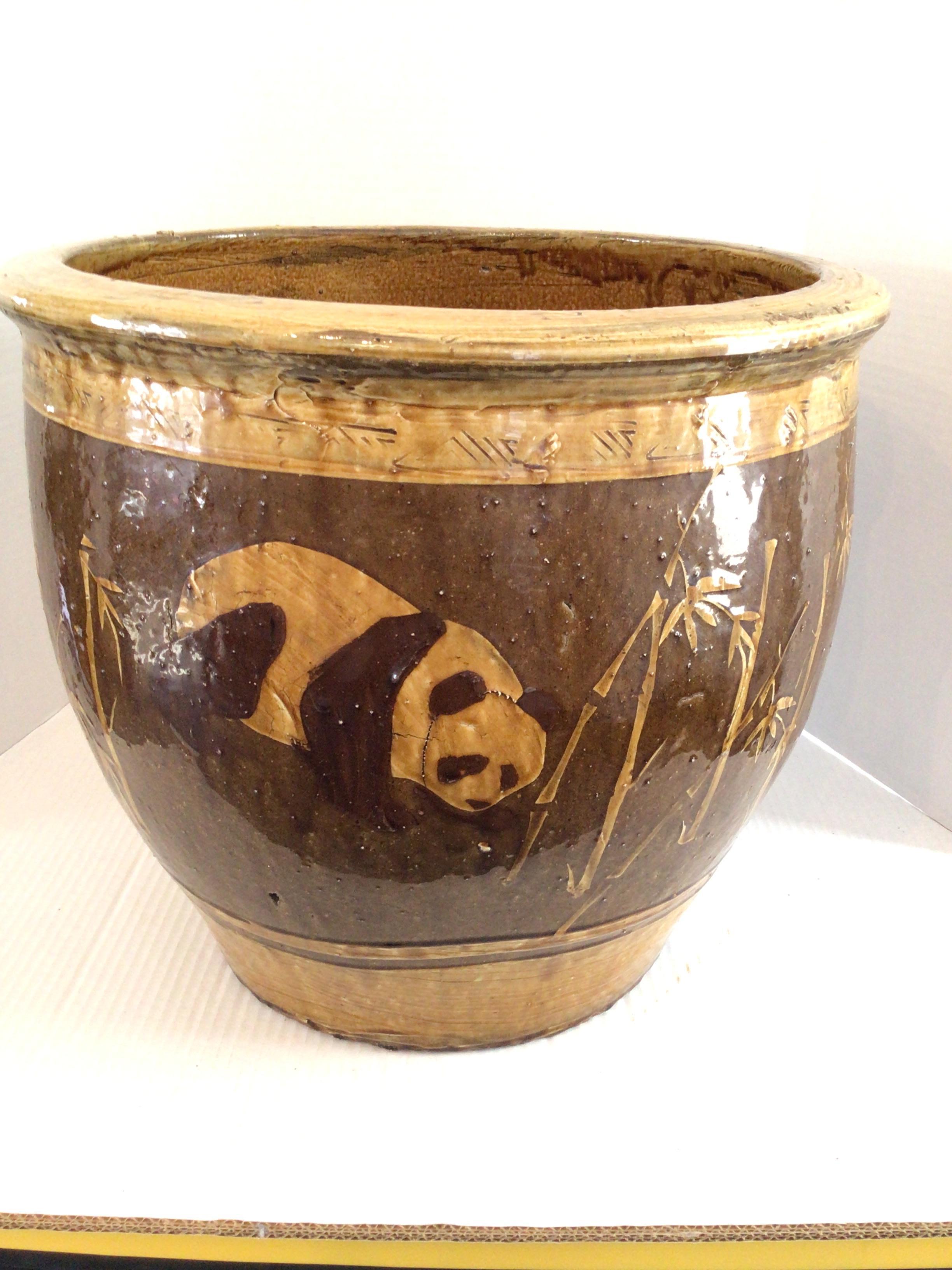 Cette jardinière en terre cuite peinte et émaillée des années 1960 représente des pandas parmi des bambous.
C'est un complément unique pour toute plante en conteneur à l'intérieur et à l'extérieur. 
