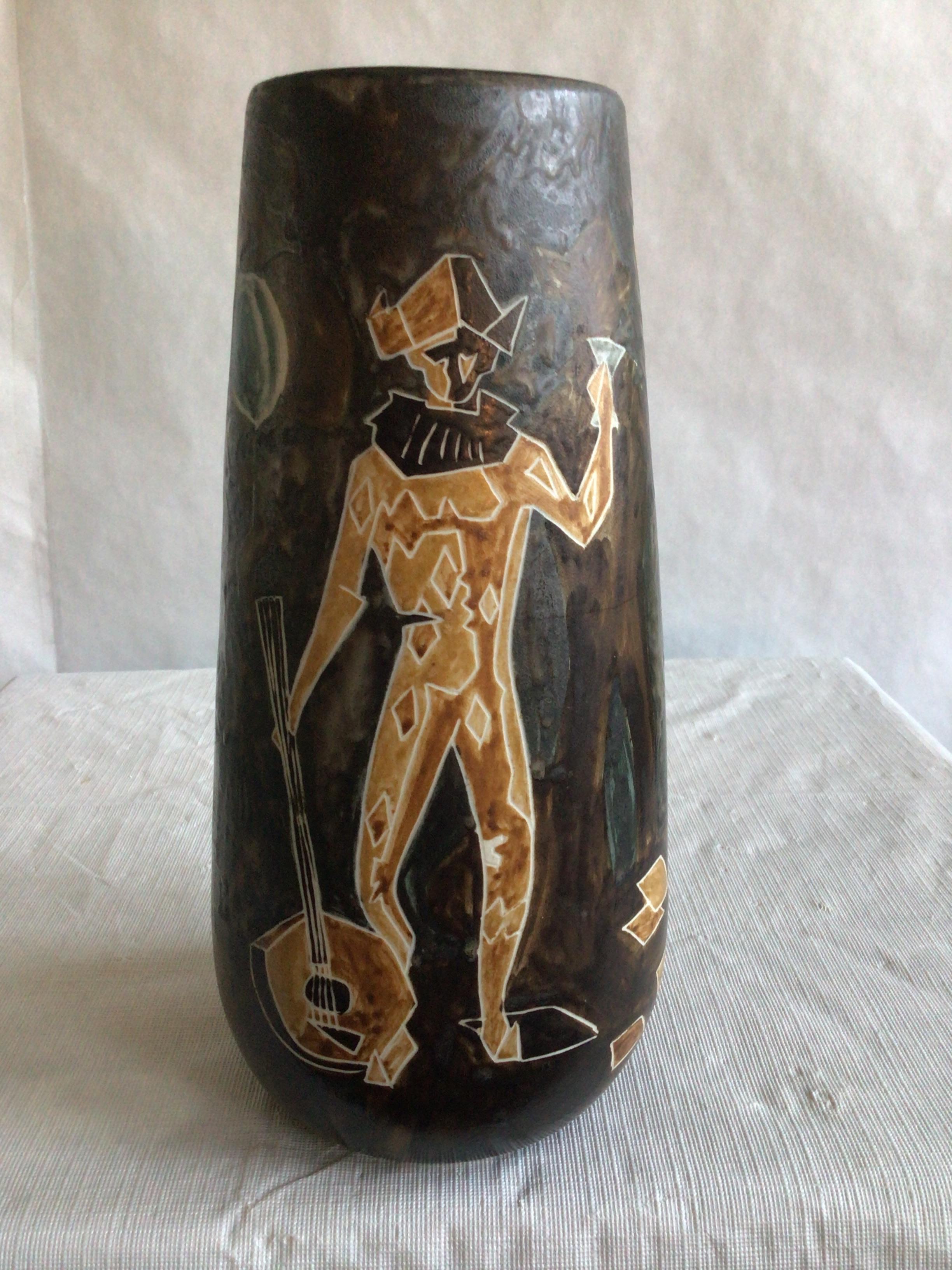 This unique 1960s Painted Ceramic Vase depicts object from a festival, celebration, fête, or even scenes from Mardi Gras/ Fat Tuesday
Brown, Gold, Blue, Cream
Painted Objects include:
Jester with guitar 
Mask
Party Hat
Playing Cards
Balloons 
Vase