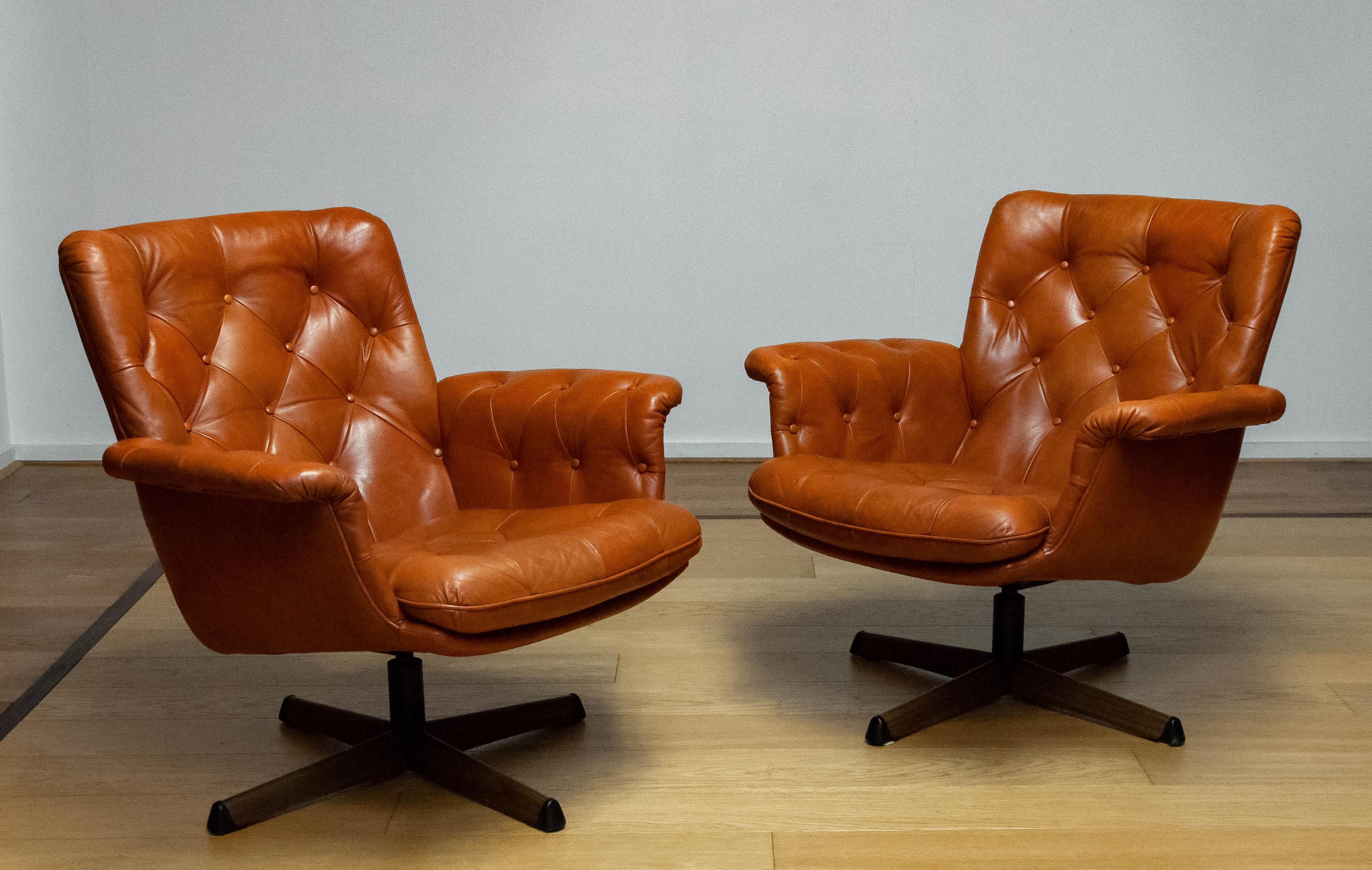 Magnifique paire de chaises pivotantes fabriquées par Göte Möbler Nässjö Suède, années 1960.
Ces chaises sont recouvertes de cuir cognac tufté et montées sur un pied pivotant en métal avec une empreinte de bois.
Les chaises sont très confortables et
