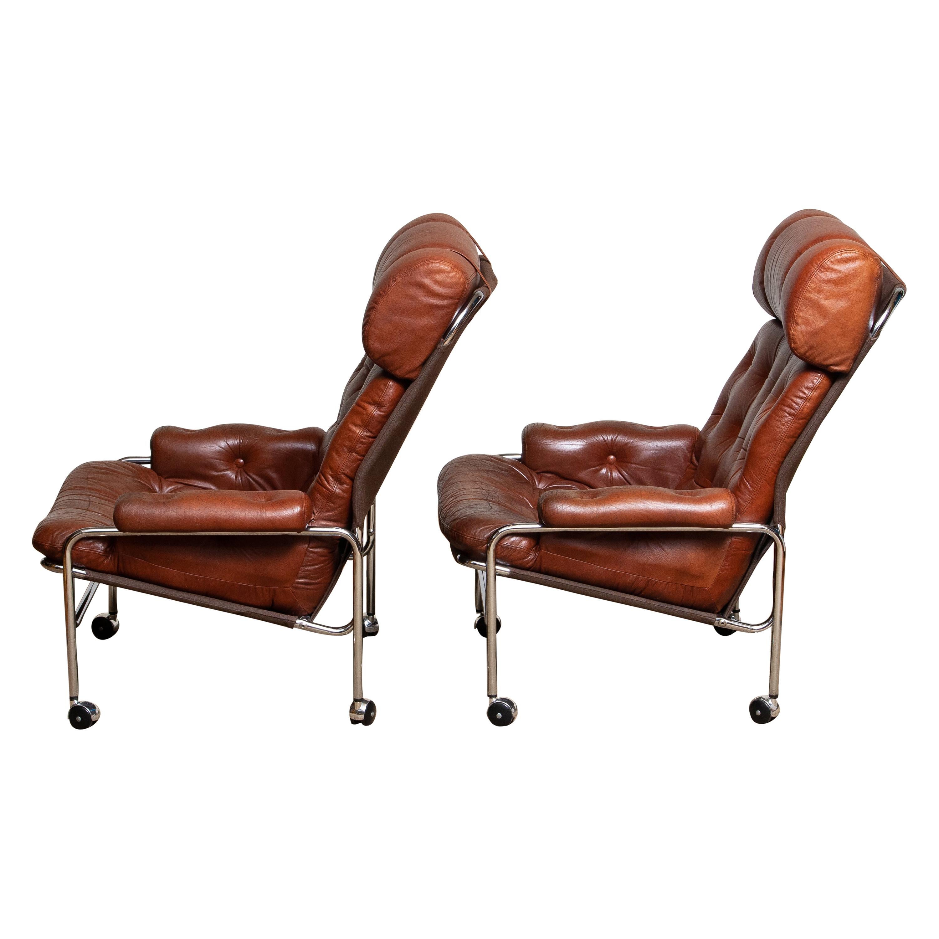 Beautiful set of two lounge / easy chair in aged brown / cognac leather and chrome designed by Pethrus Lindlöfs for A.B. Lindlöfs Möbler Lammhult, Sweden.
The aged leather on both chairs gives them there typical vintage character. The leather is