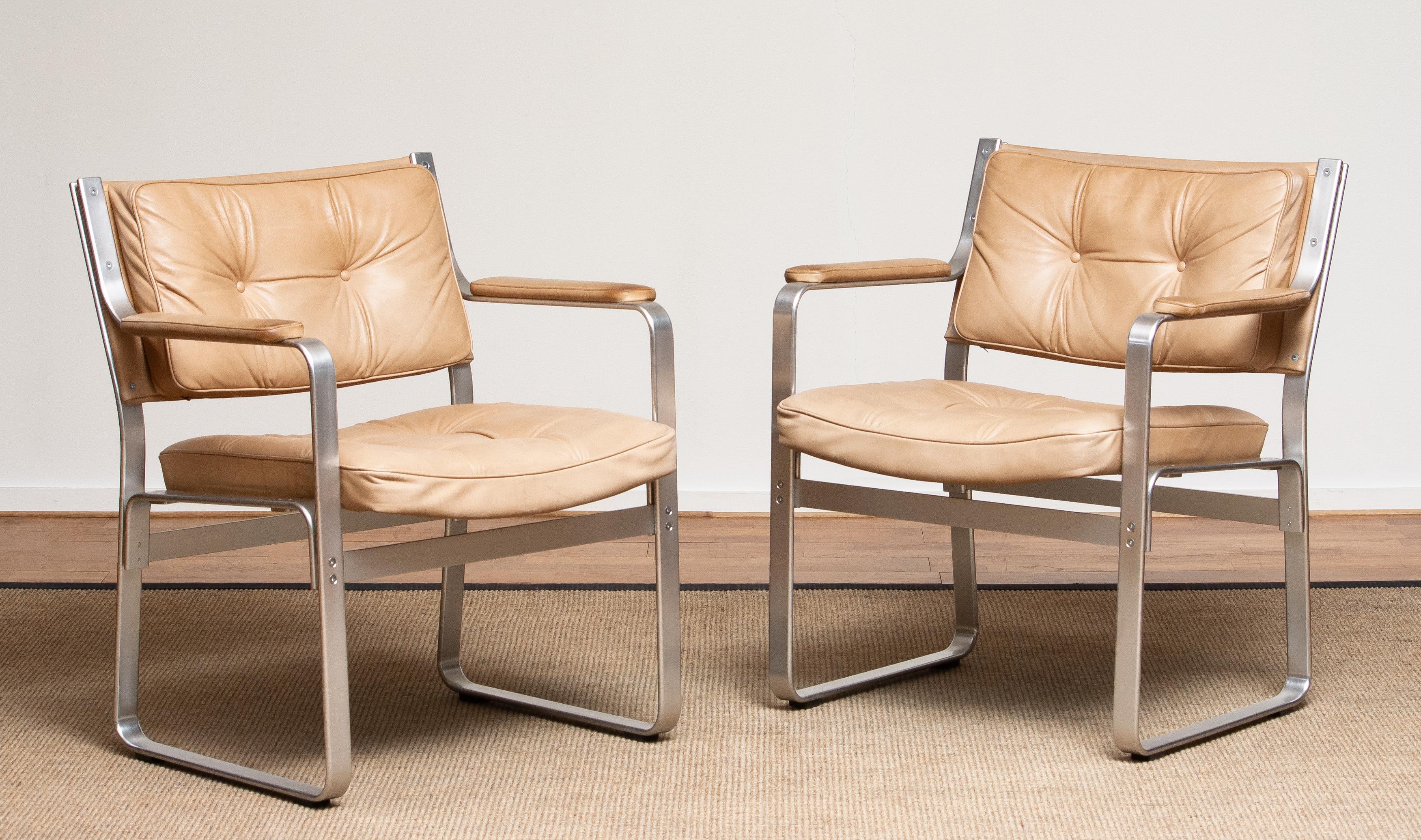 1960's set of two 'Mondo' armchairs in aluminum with beige / taupe leather upholstery designed by Karl Erik Ekselius for J.O. Carlsson / JOC design in Sweden.
Both chairs are in perfect condition and completely original. The fillings in de seats