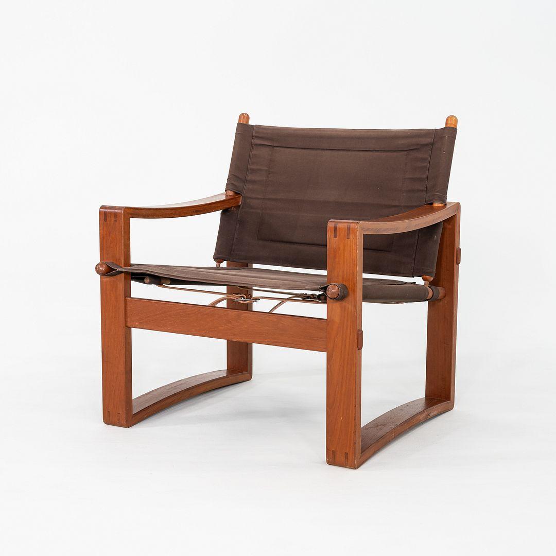 Se trata de un par de sillas Safari, diseñadas originalmente por Borge Jensen. Estos ejemplares en concreto fueron fabricados por Bernstorffsminde Mobelfabrik en Dinamarca en la década de 1960. Se componen de un armazón de teca, su lona original y