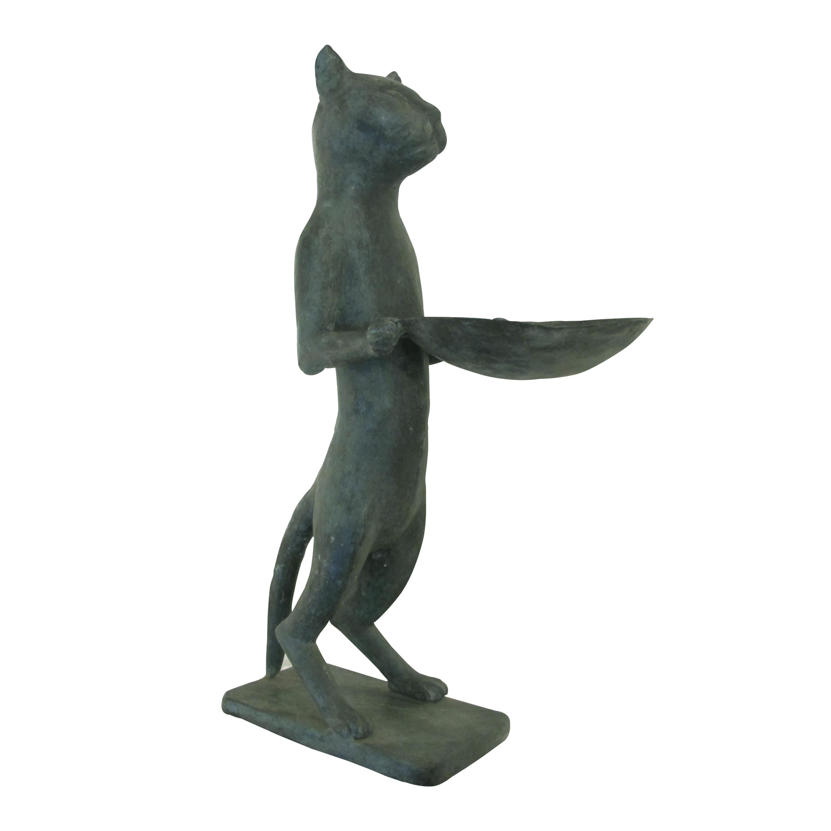These tall bronze cat statues are designed in a style reminiscent of Diego Giacometti's works. Likely created in the 1960s in England, the statue features a stylized cat standing upright on its hind legs, holding a dish or tray in its front paws.