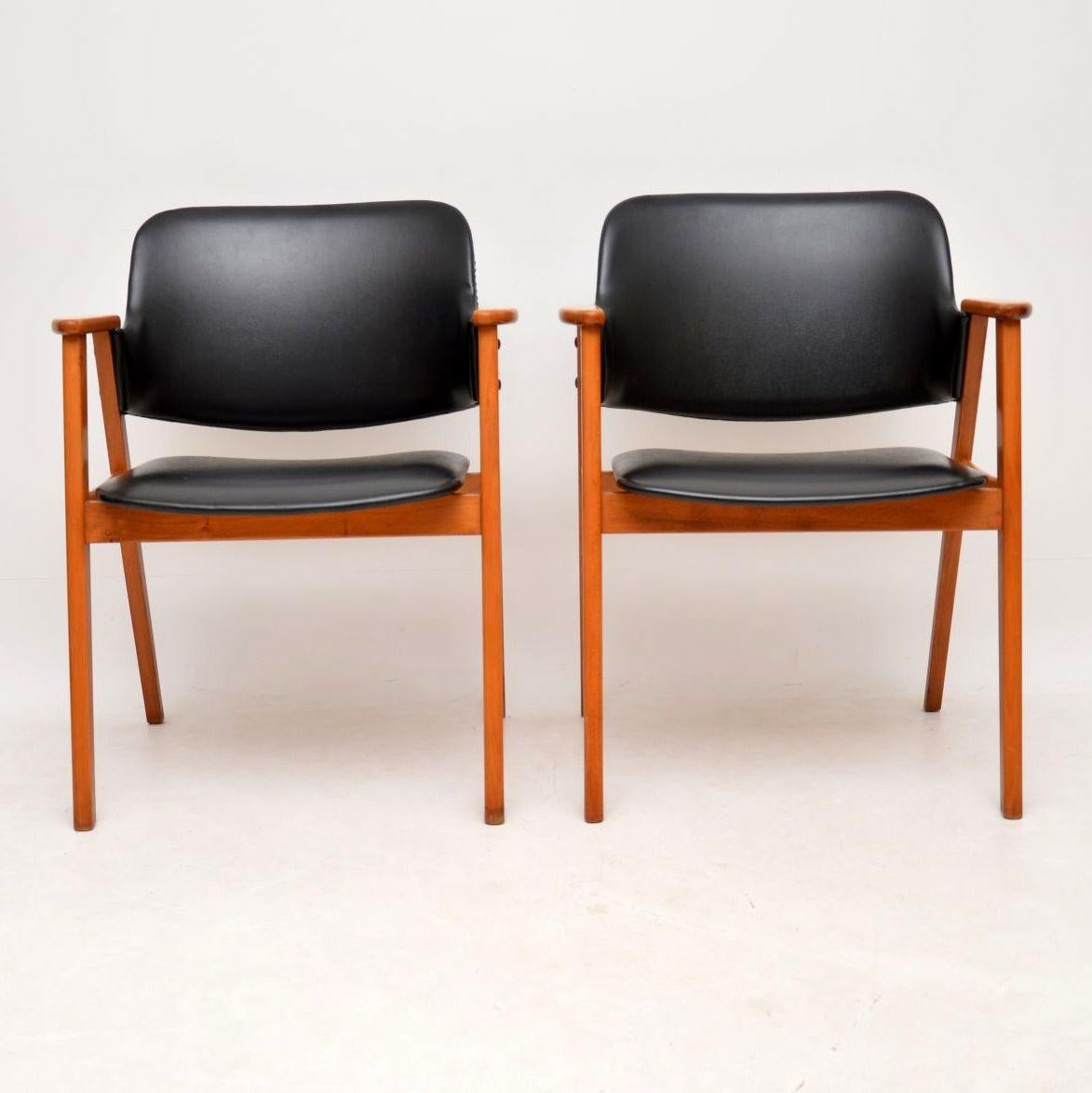 A beautifully styled and elegant pair of vintage open armchairs, these were made in Denmark, they date from the 1960s. The solid Beech frames are very clean and in good condition with only minor surface wear; the original black vinyl upholstery is