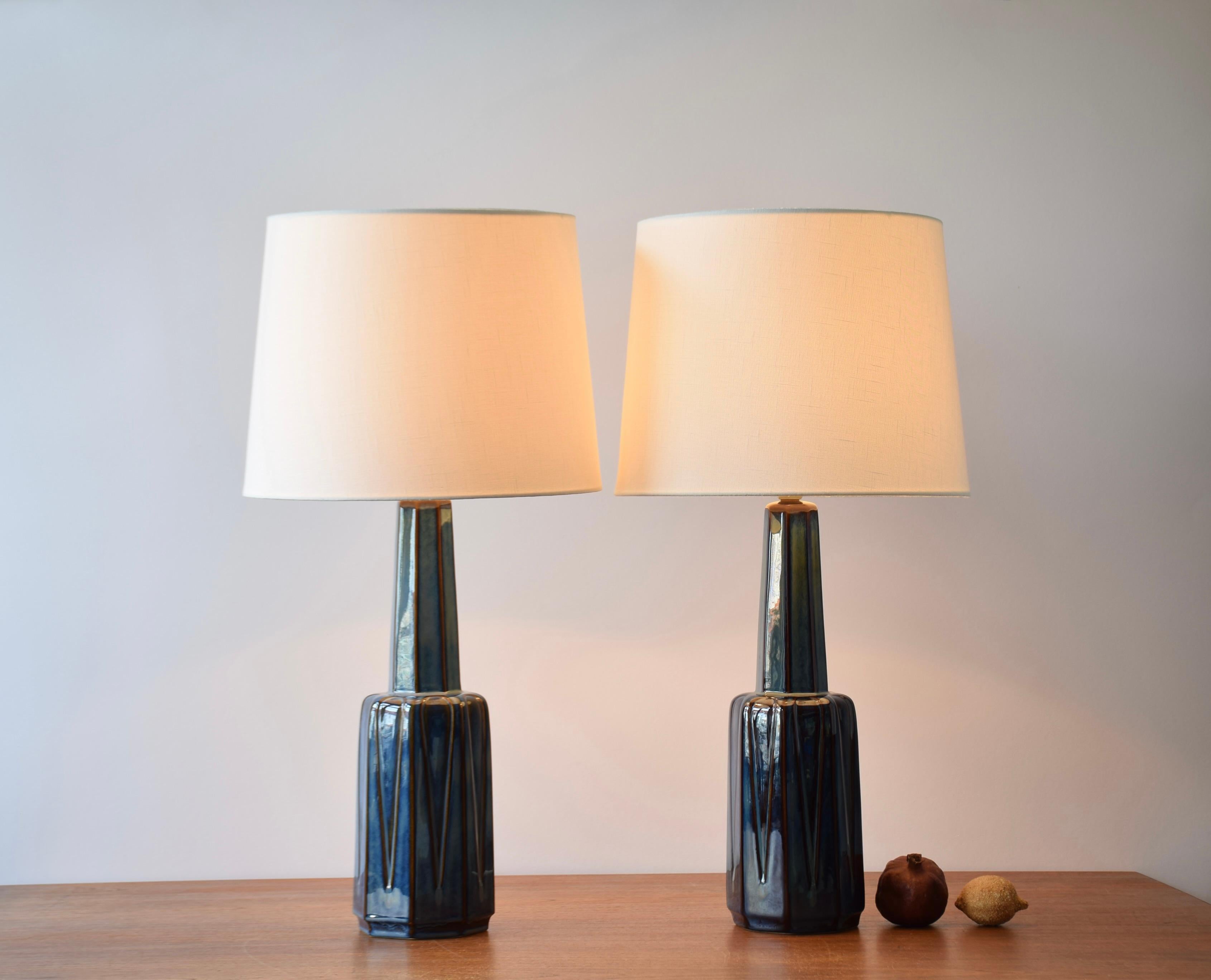 Pair of stylish tall Mid-century Danish table lamps from the acknowledged stoneware manufacturer Søholm. Manufactured circa 1960s. The designer is unknown but we suppose they were designed by Einar Johansen.

The lamps have a blue glaze with