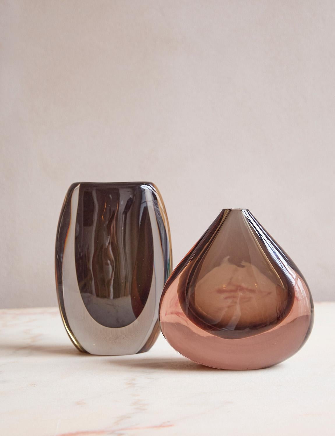 Two Murano glass vases by different creative directors, Flavio Poli and Cenedese, yet they both use the same sommerso (submerged glass) technique. The first Murano Vase by Flavio Poli has a deep brown core and pale pinkish surround. It is hand-blown