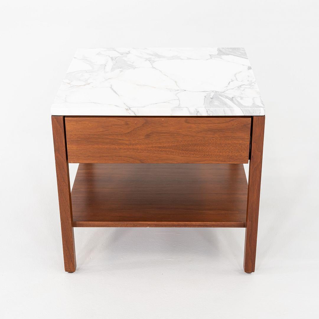 Si tratta di una coppia di comodini in noce Florence Knoll, modello 327 IS, progettati originariamente nel 1956. Questi esemplari in particolare risalgono agli anni '60 e hanno il piano in marmo bianco. Il design è caratterizzato da una cassa in