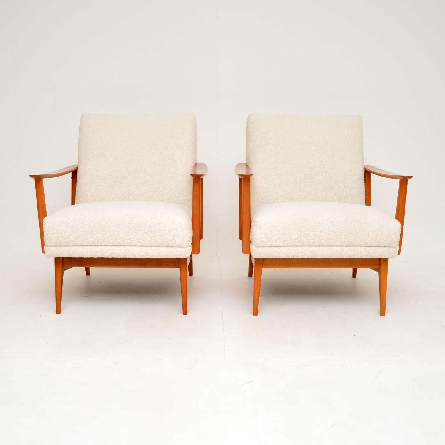 A very stylish and extremely comfortable pair of vintage French armchairs. They were recently imported from France, and they date from the 1960’s.

The quality is amazing, with beautifully crafted cherry wood frames. The open arms have a slender yet