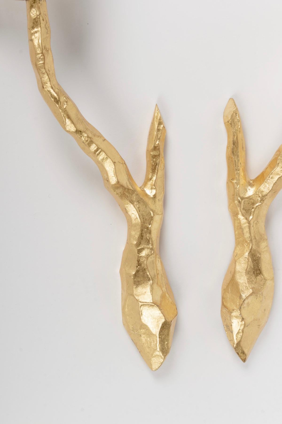 Elegant gilded bronze sconces designed by the Maison Arlus in the 1960s. The two arms figure a stylized branch. They hold the original cylindrical white satin glass shades.
One bulb per sconce.

   