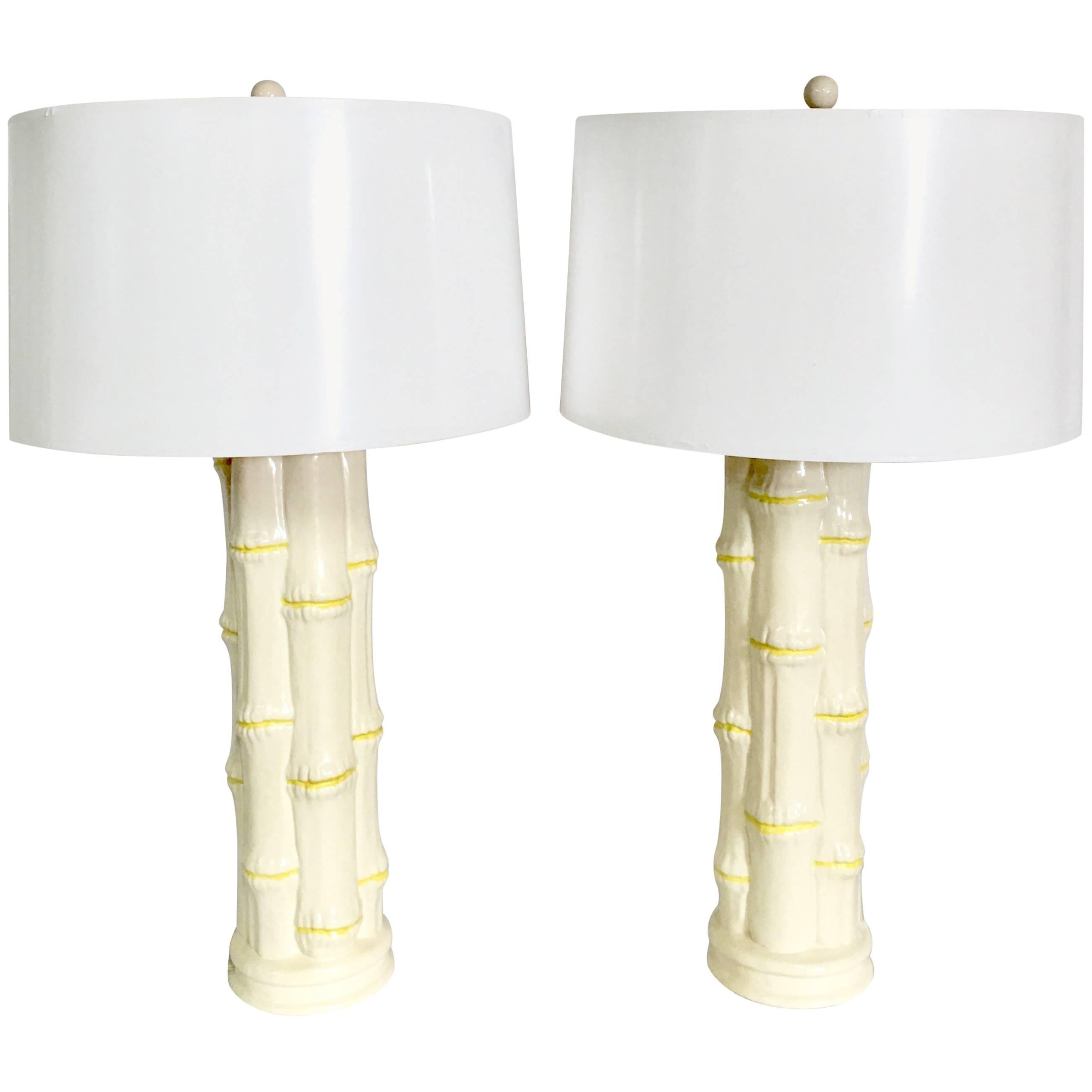 1960s pair of Hollywood Regency tall ceramic glaze dimensional white and yellow faux bamboo table lamps. Features original brass fittings. Includes pair of white ceramic round finial and gold brass harps. Wired for the US and in working order. Takes