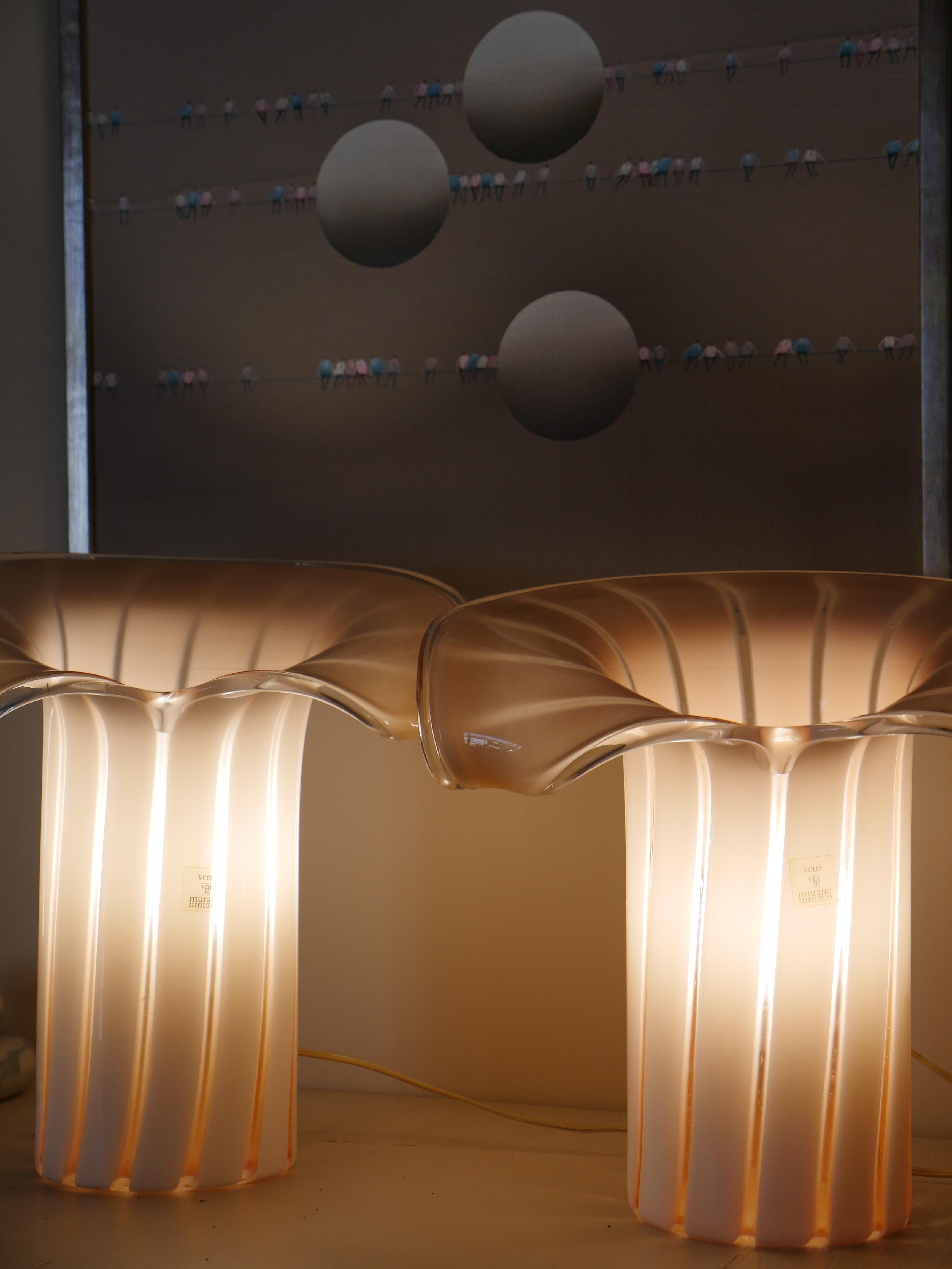 Una bellissima coppia di grandi lampade da tavolo in vetro di Murano degli anni '60, realizzate da Gino Vistosi per Vetri, Italia. Scolpite da un unico pezzo di vetro, queste forme luminose si ispirano alle curve eleganti di una calla, fondendo