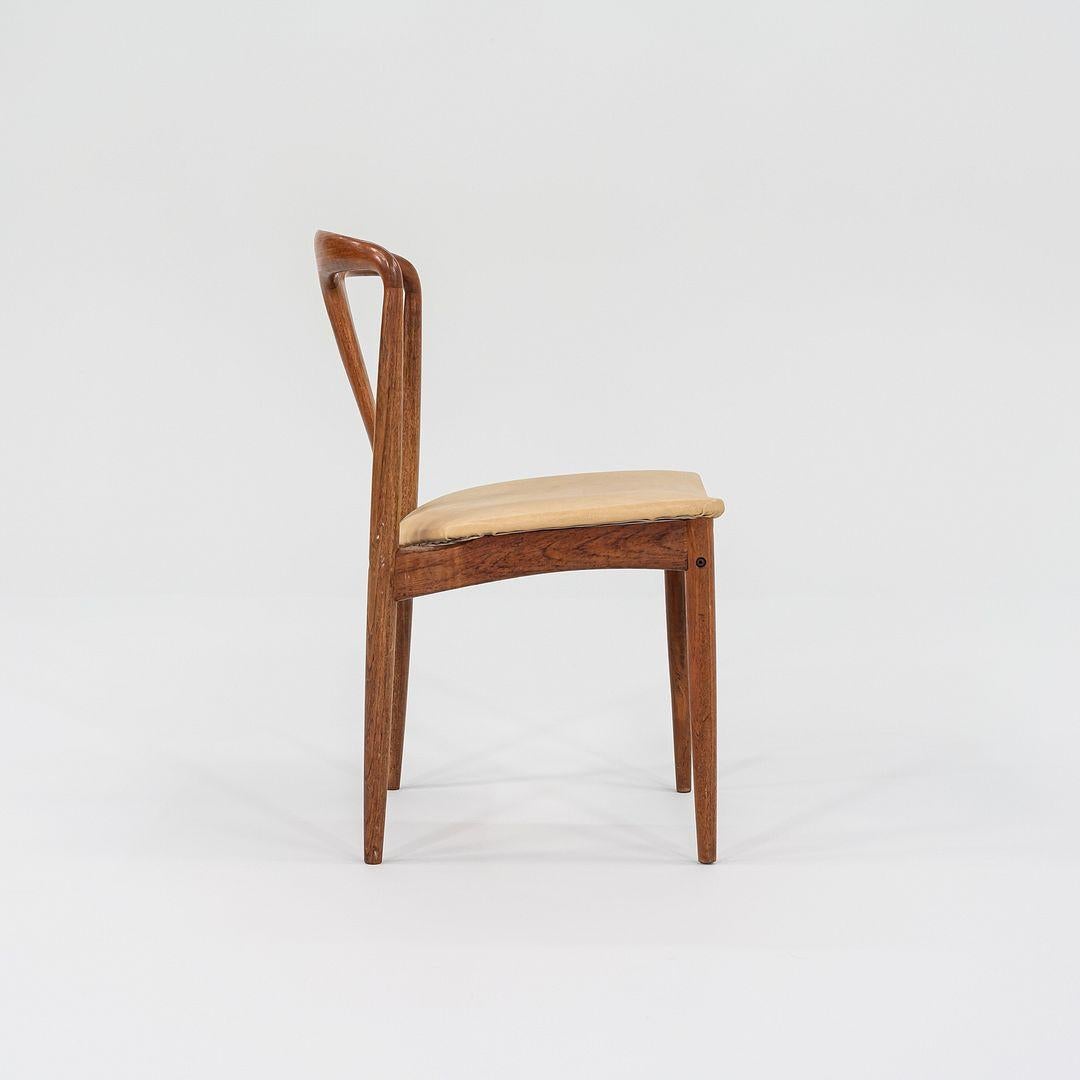 This is a pair of Juliane Teak Dining Room Chairs, originally designed by Johannes Andersen. These particular pieces were produced by Uldum Mobelfabrik in Denmark in the 1960s. The chairs are comprised of a teak frame with a tan leather upholstered