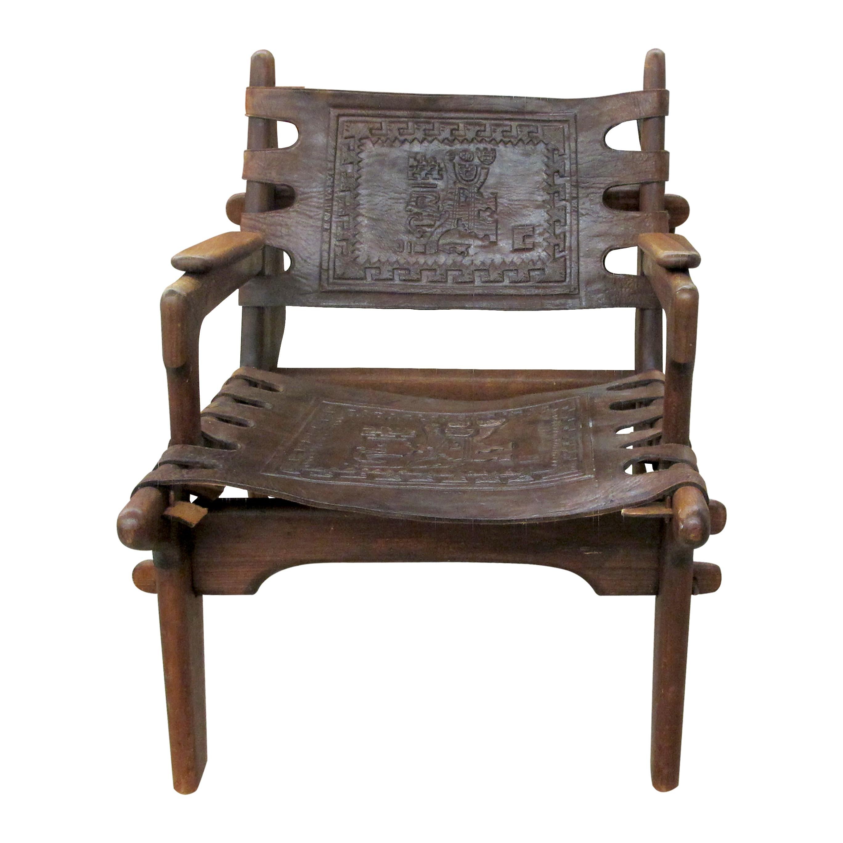 Mid-century comfortable pair of hardwood and tooled leather boasting Inca motifs designed by Angel Pazmino for Muebles De Estilo in Ecuador. The wooden frames feature interlocking joints and the leather is held together by rugged pegs. The leather