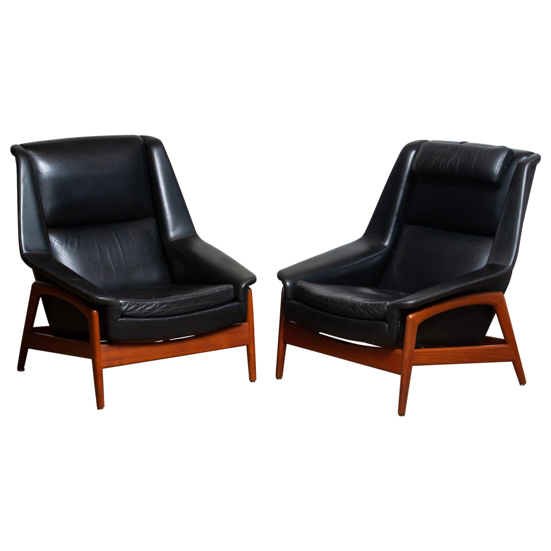 Stunning set of two easy or lounge chair in teak and upholstered with black leather by Folke Ohlsson for DUX, Sweden, model: Profil overall in good and both in original condition. Note the there is one head cushion.