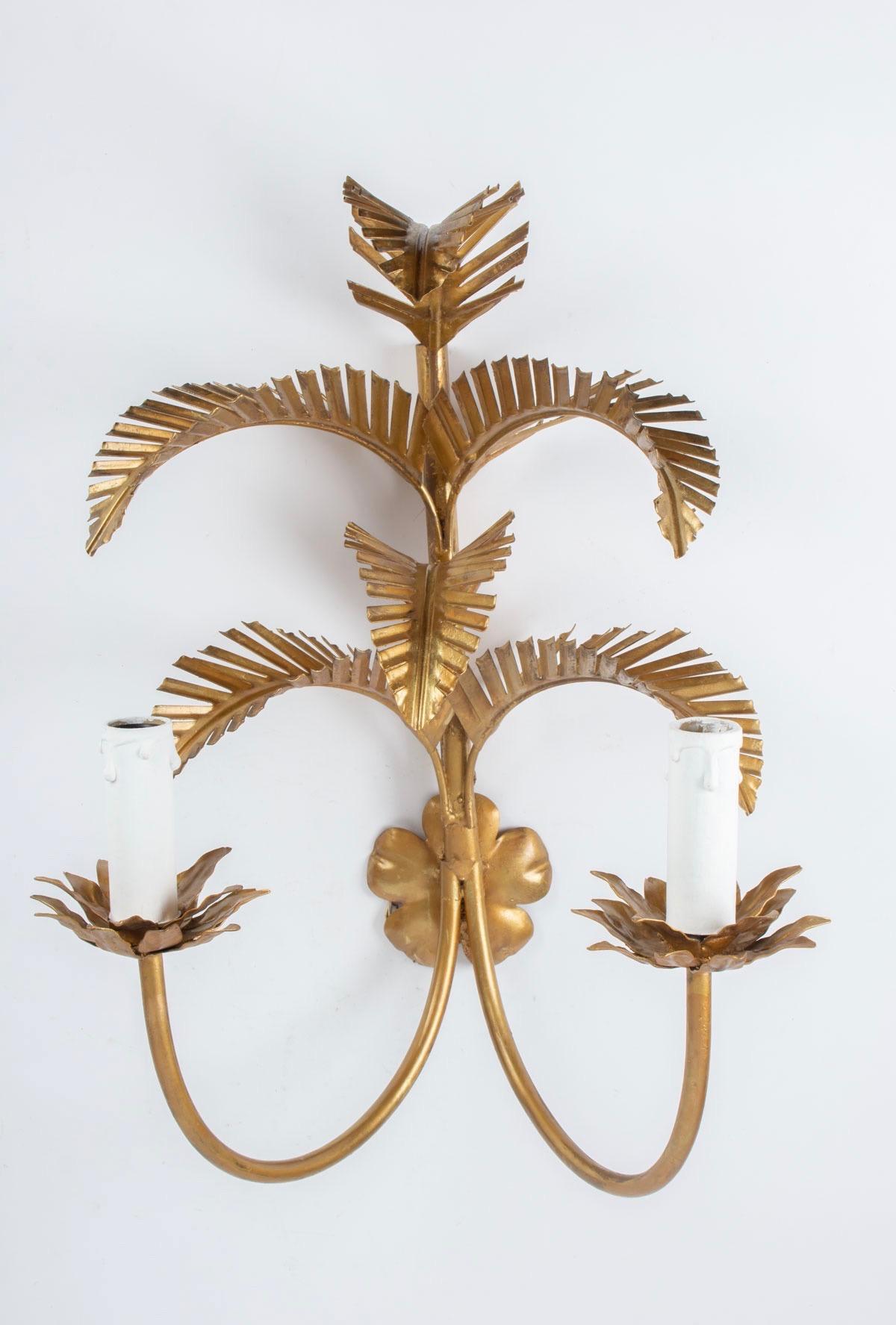 1960s pair of Maison FlorArt gilded palm leaves sconces
Each sconce features six palm leaves and two lighted arms.
The bulb holder figures a stylized flower.
Two bulbs per sconce.