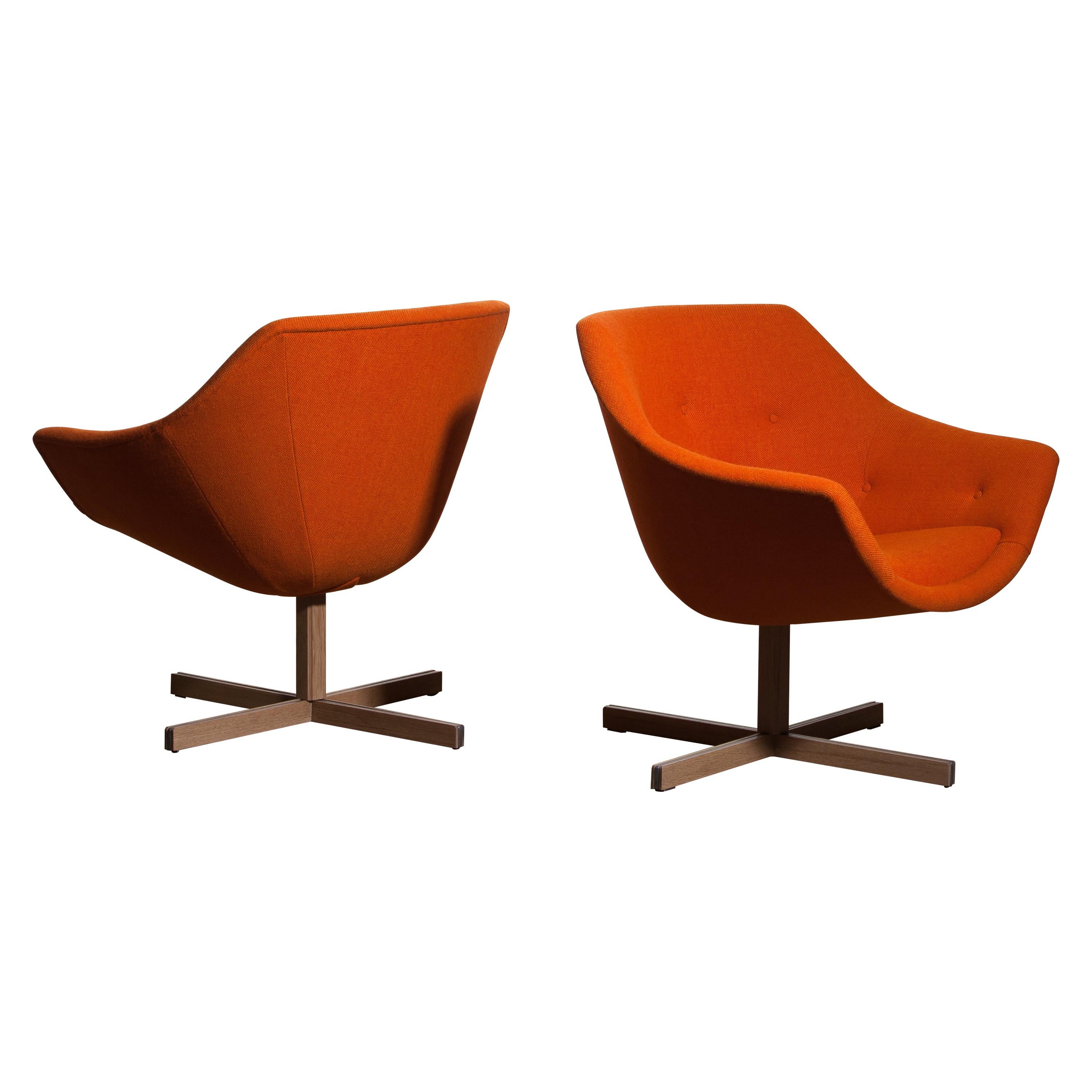 Fantastic pair of 'Mandarini' swivel armchairs made by Carl Gustaf Hiort for Puunveisto Oy - Wood work Ltd.
These chairs are upholstered with a buttoned orange fabric 'Hallingdal' by Kvadrat designed by Nanna Ditzel, on a oak swivel base.
They are