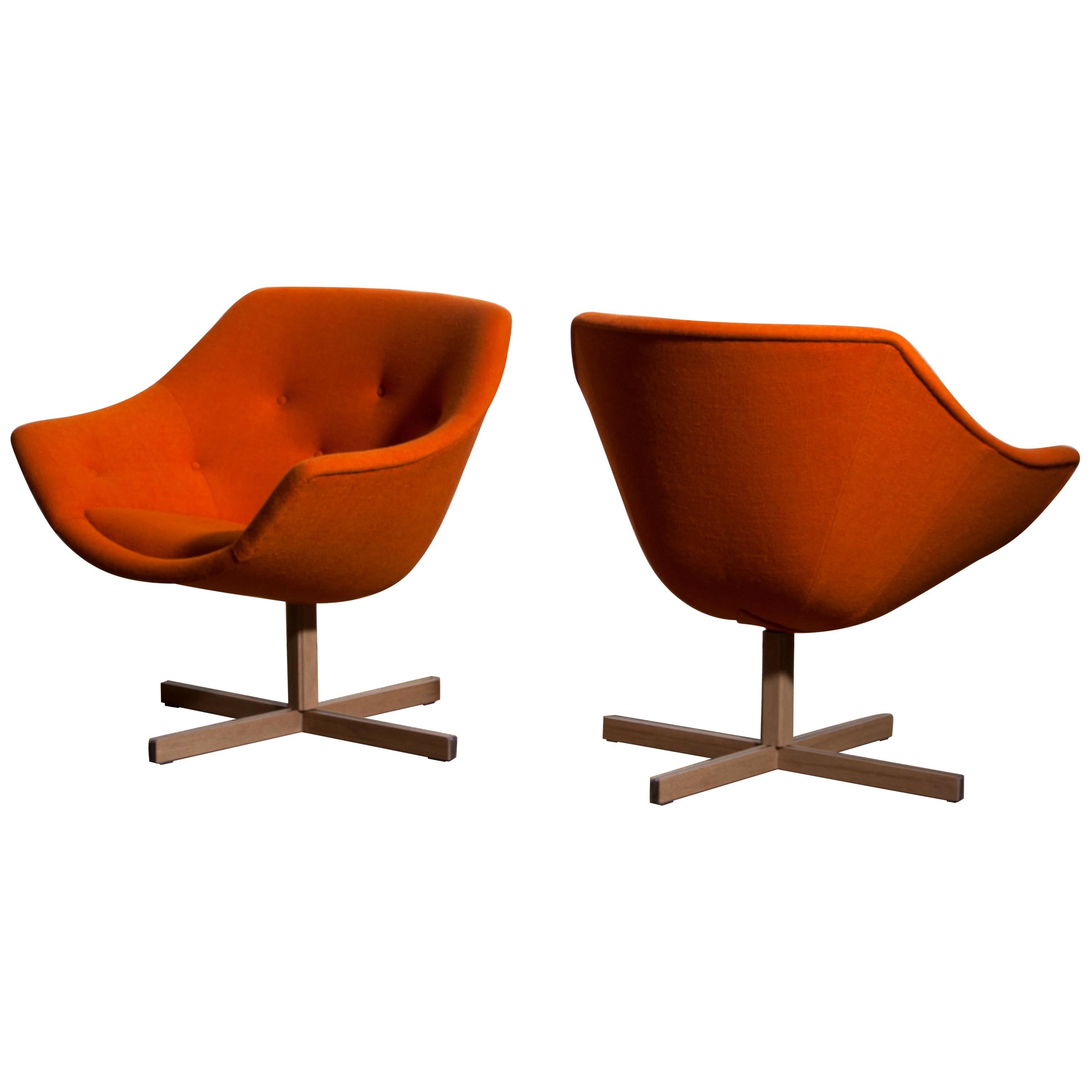 Fantastic pair of 'Mandarini' swivel armchairs made by Carl Gustaf Hiort for Puunveisto Oy, wood work Ltd.
These chairs are upholstered with a buttoned orange fabric 'Hallingdal' by Kvadrat designed by Nanna Ditzel, on an oak swivel base.
They are