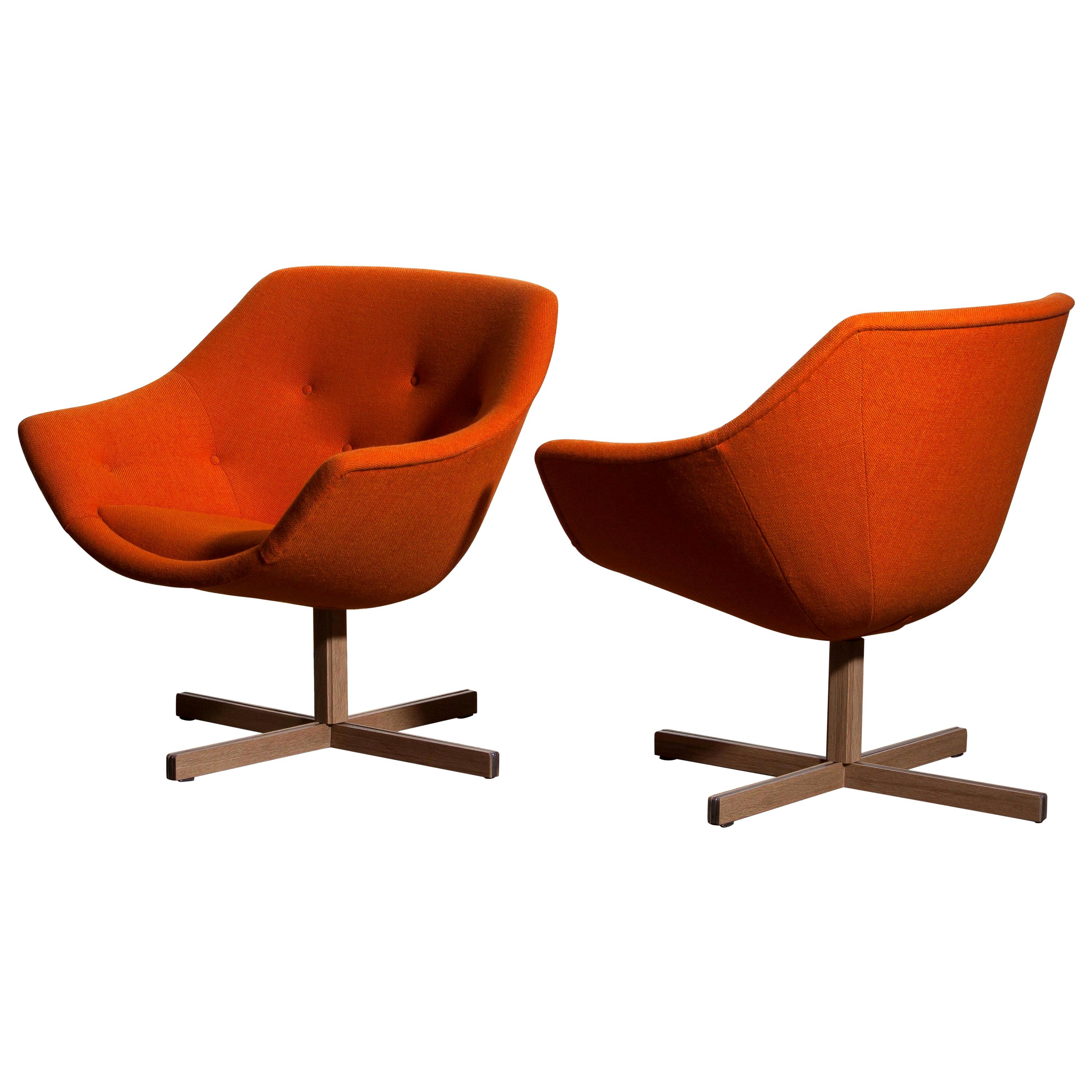 Fantastic pair of 'Mandarini' swivel armchairs made by Carl Gustaf Hiort for Puunveisto Oy, wood work Ltd.
These chairs are upholstered with a buttoned orange fabric 'Hallingdal' by Kvadrat designed by Nanna Ditzel, on an oak swivel base.
They are